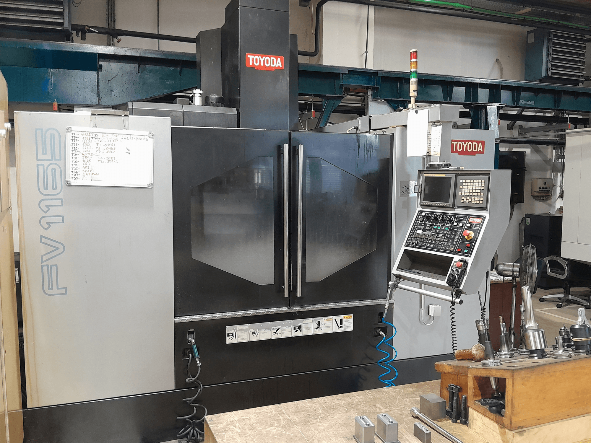 Pionowe centrum obróbcze TOYODA FV 1165, widok z przodu, panel sterowania i wskaźniki operacyjne.