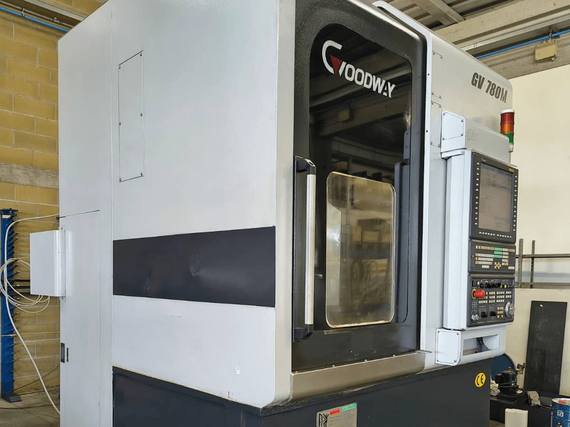 Tokarka pionowa Goodway GV 780 M, widok z boku, panel sterowania, funkcje bezpieczeństwa i czysty wygląd zewnętrzny.