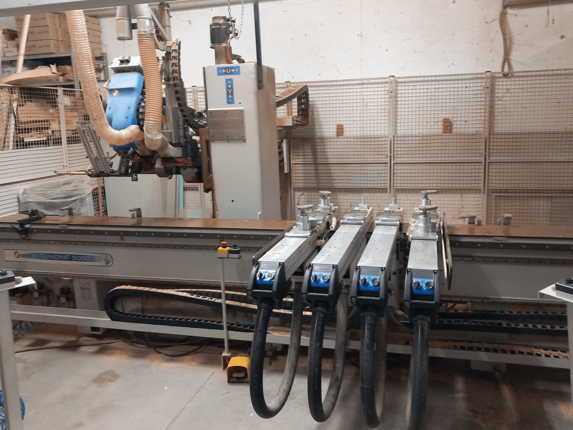 Centrum obróbki drewna CNC MASTERWOOD TEKNOMAT 5000, widok z przodu przedstawiający głowicę narzędziową i liczne węże ssące.