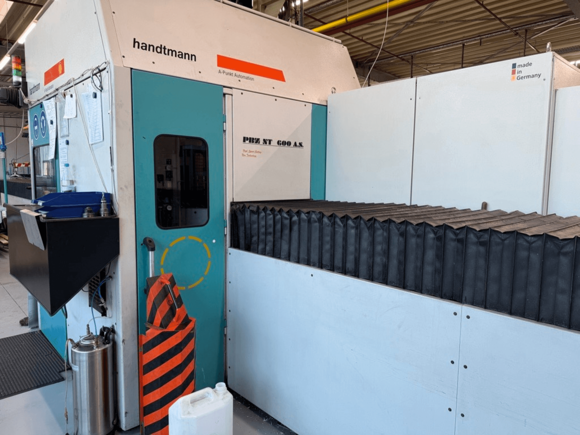 Widok z przodu frezarki bramowej Handtmann PBZ NT 600 AS z ciemną powierzchnią roboczą i barierami bezpieczeństwa.