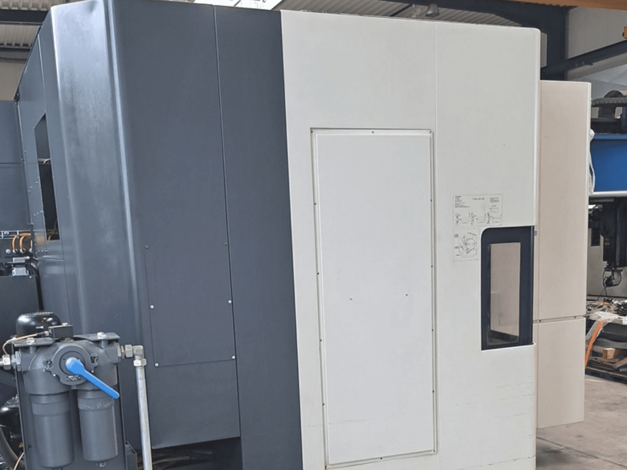 Poziome centrum obróbcze DMG MORI NHX5000 – widok z boku przedstawiający panel sterowania i elementy mechaniczne.