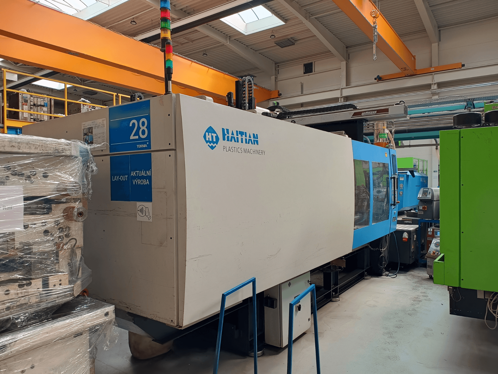 Hydrauliczna wtryskarka HAITIAN MARS 5300/4500, widok z przodu, panel sterowania i niebiesko-biała obudowa.