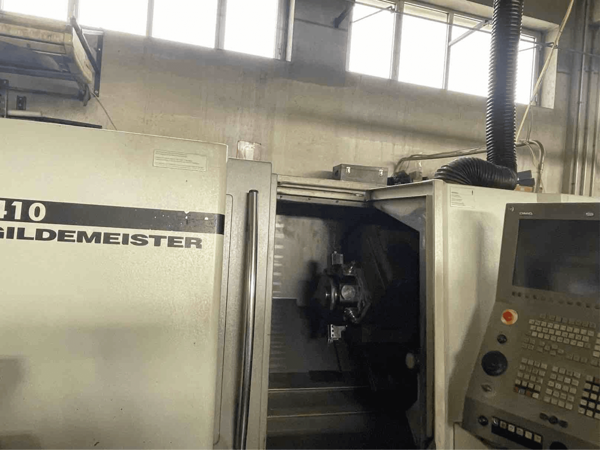 Tokarka pozioma DMG CTX410, widok z przodu, pokazujący panel sterowania i widoczne elementy obróbcze wewnątrz.