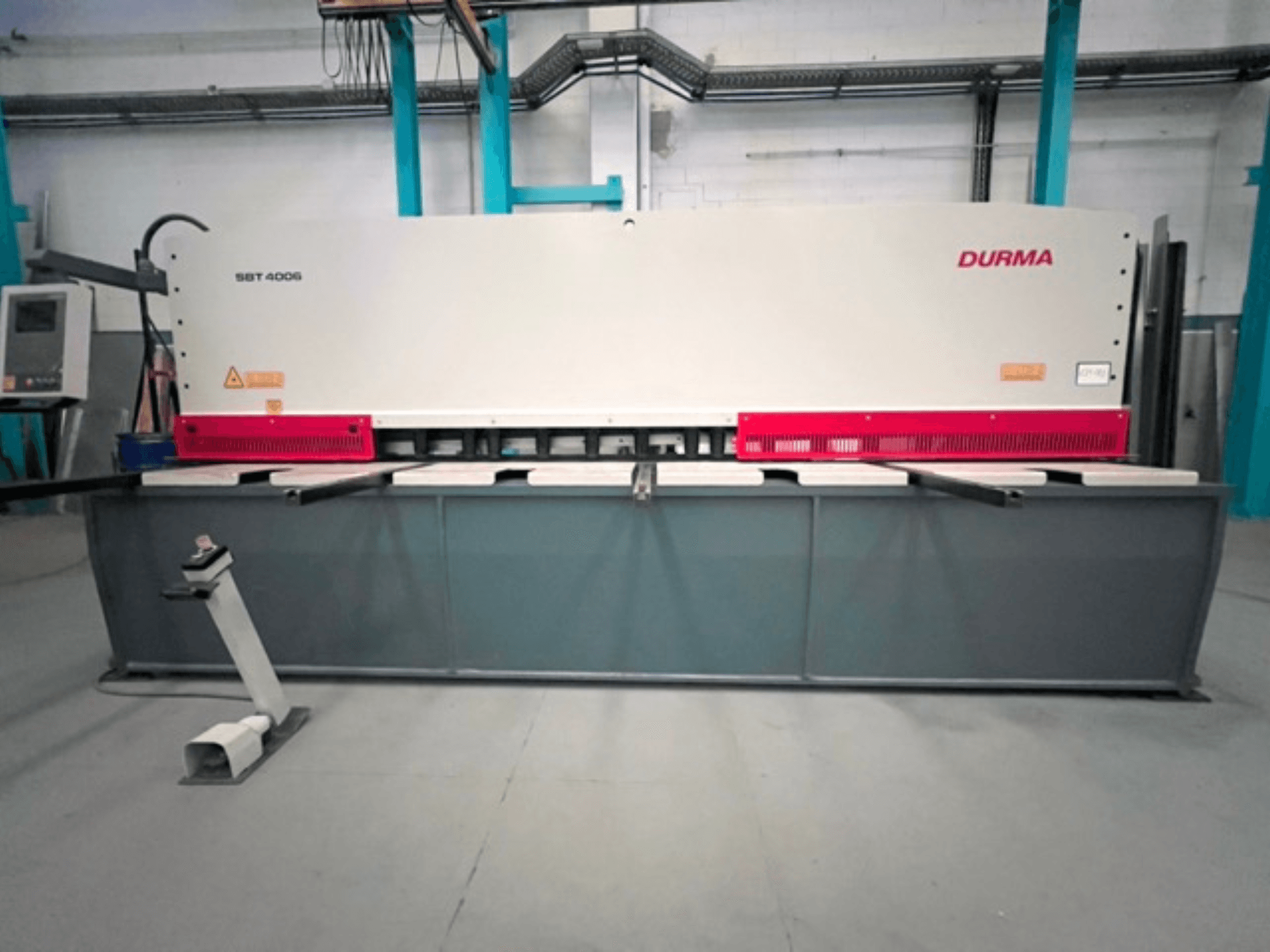Nożyce CNC Durma SBT 4006 w widoku z przodu, z szarą podstawą i czerwonymi akcentami, gotowe do pracy w fabryce.