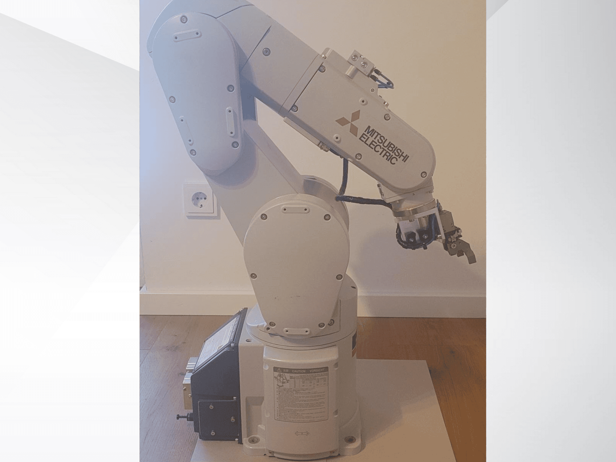 Ramię robotyczne Mitsubishi Electric, widok z boku, z chwytakiem i szczegółowym panelem sterowania na podstawie do ustawień operacyjnych.