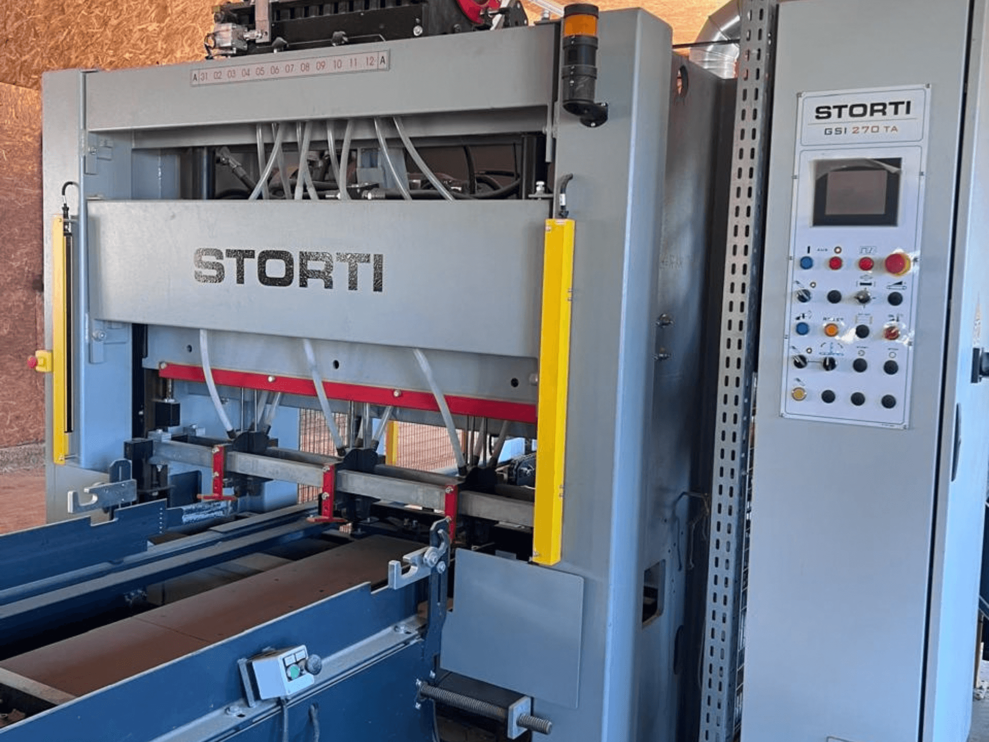 Linia do obróbki drewna STORTI GSI 170-270 TA9 – widok z przodu przedstawiający panel sterowania oraz mechanizmy prasy hydraulicznej.