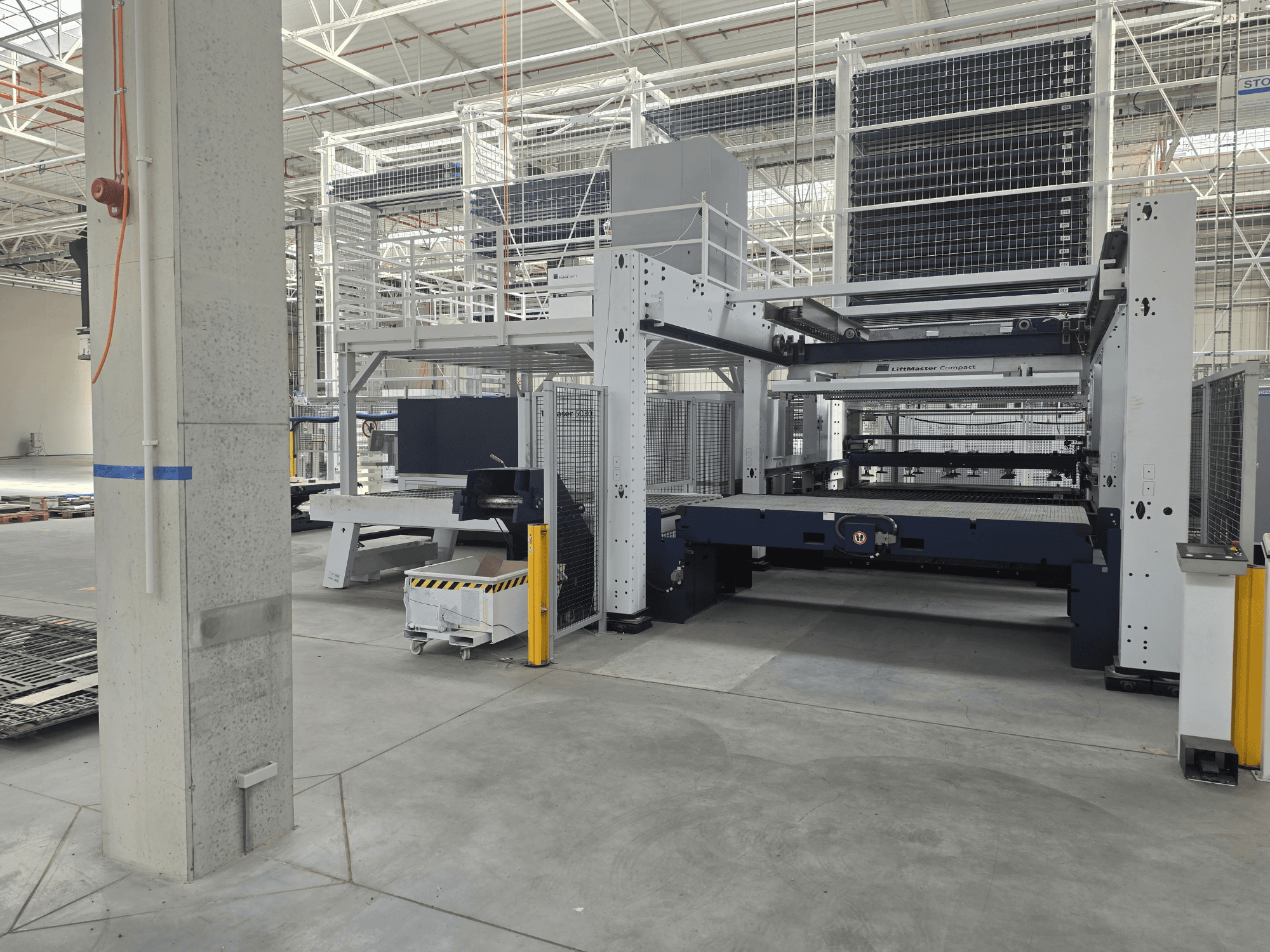 Widok z przodu maszyny TRUMPF TruLaser 5030 fiber L76 FMC, przedstawiający laserową wycinarkę światłowodową w przestronnym otoczeniu przemysłowym.