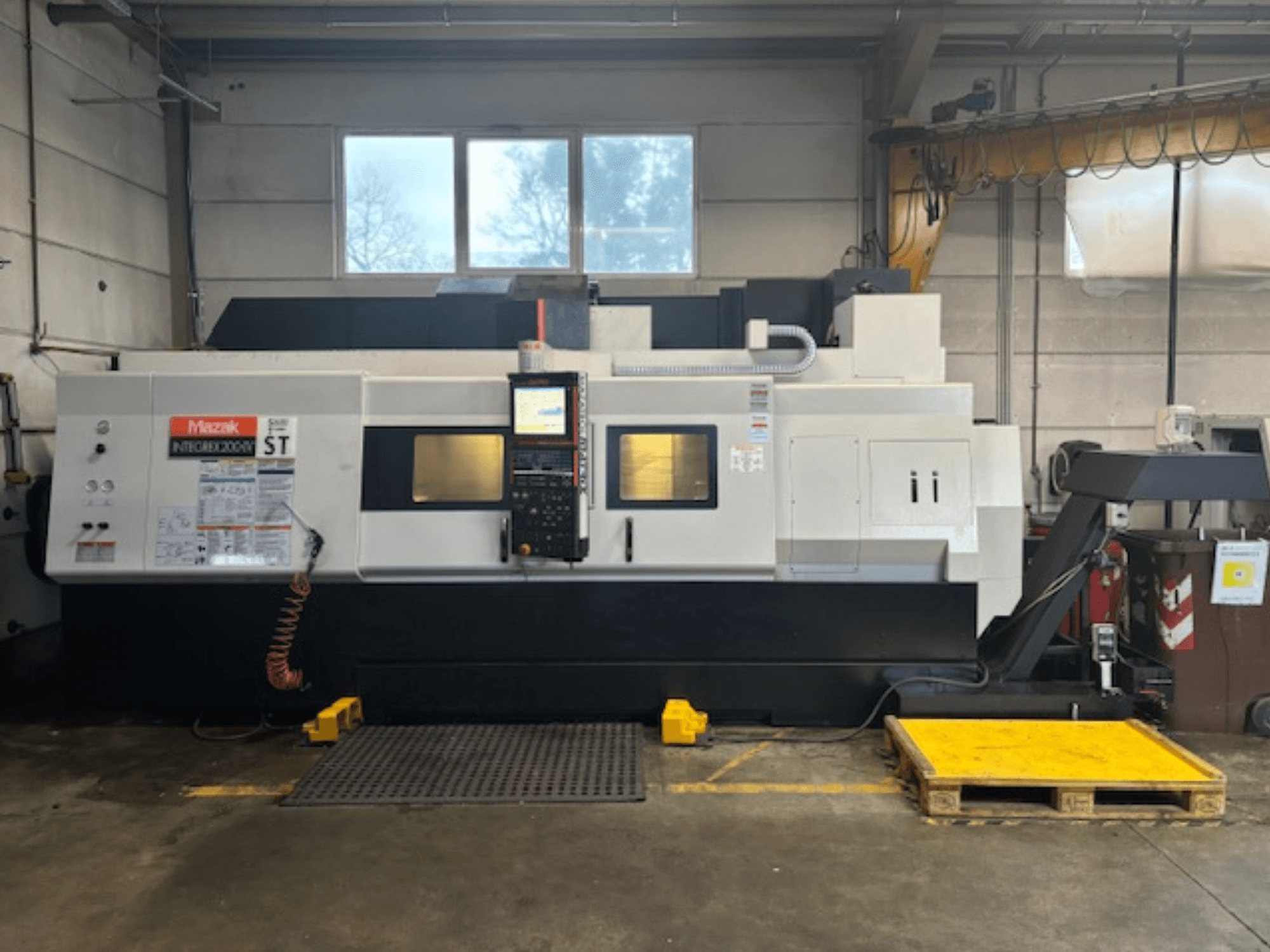 Mazak Integrex 200 SY ST, widok z boku, pokazujący panel sterowania, wyświetlacze operacyjne i przewody chłodziwa w warunkach warsztatowych.