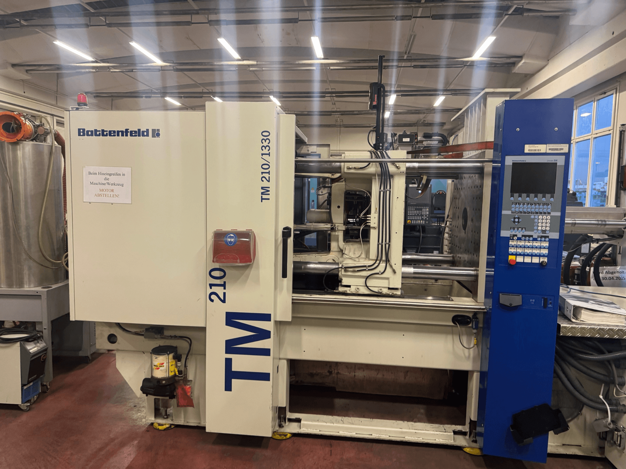 Wtryskarka hydrauliczna Battenfeld TM 210/1330, widok z przodu, pokazujący panel sterowania i komponenty maszyny.