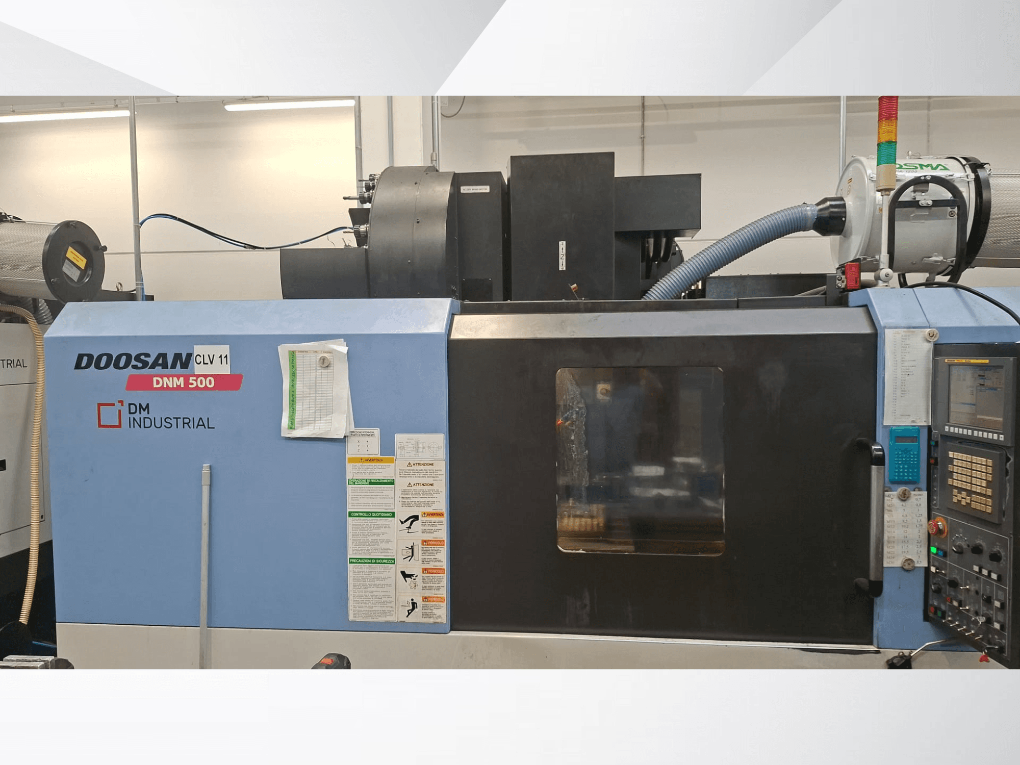 Pionowe centrum obróbcze DOOSAN DNM 500 – widok z boku, przedstawiający panel sterowania i elementy robocze.