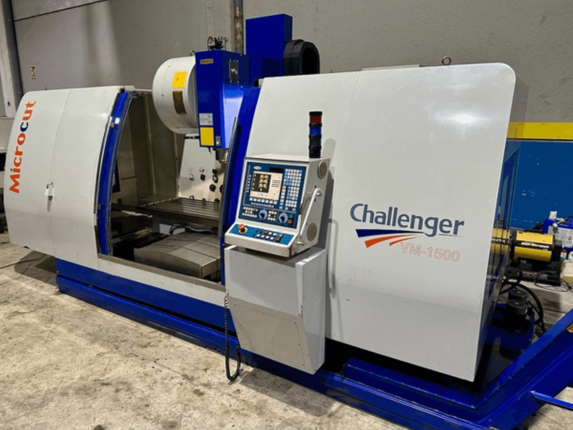 Maszyna CNC Microcut Challenger VM-1500, widok z przodu, z panelem sterowania, obszarem roboczym i niebieską podstawą.