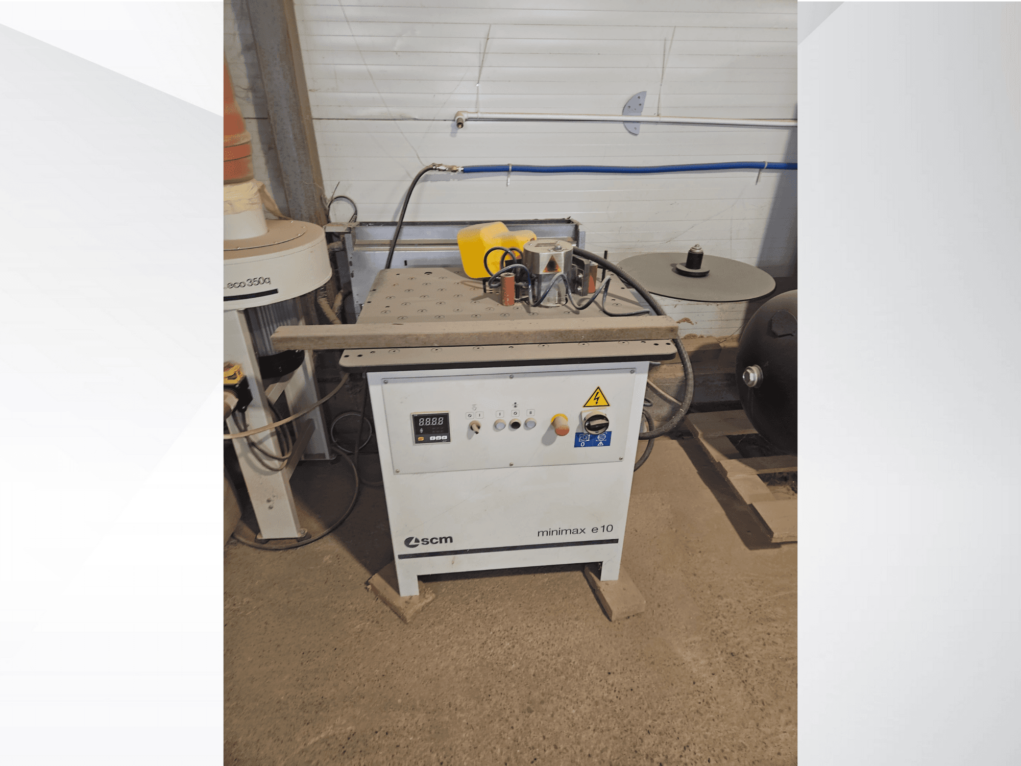 Maszyna do obróbki drewna SCM Minimax E10, widok z przodu, z panelem sterowania, portem przeciwpyłowym i regulowaną powierzchnią roboczą.