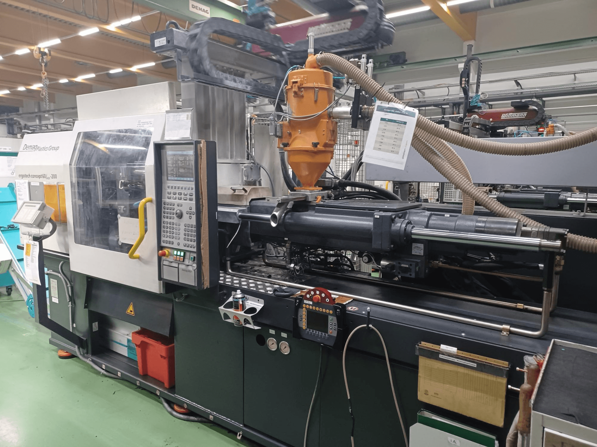 Wtryskarka Demag Ergotech 200, widok z przodu z widocznym panelem sterowania, dyszą i komponentami operacyjnymi.