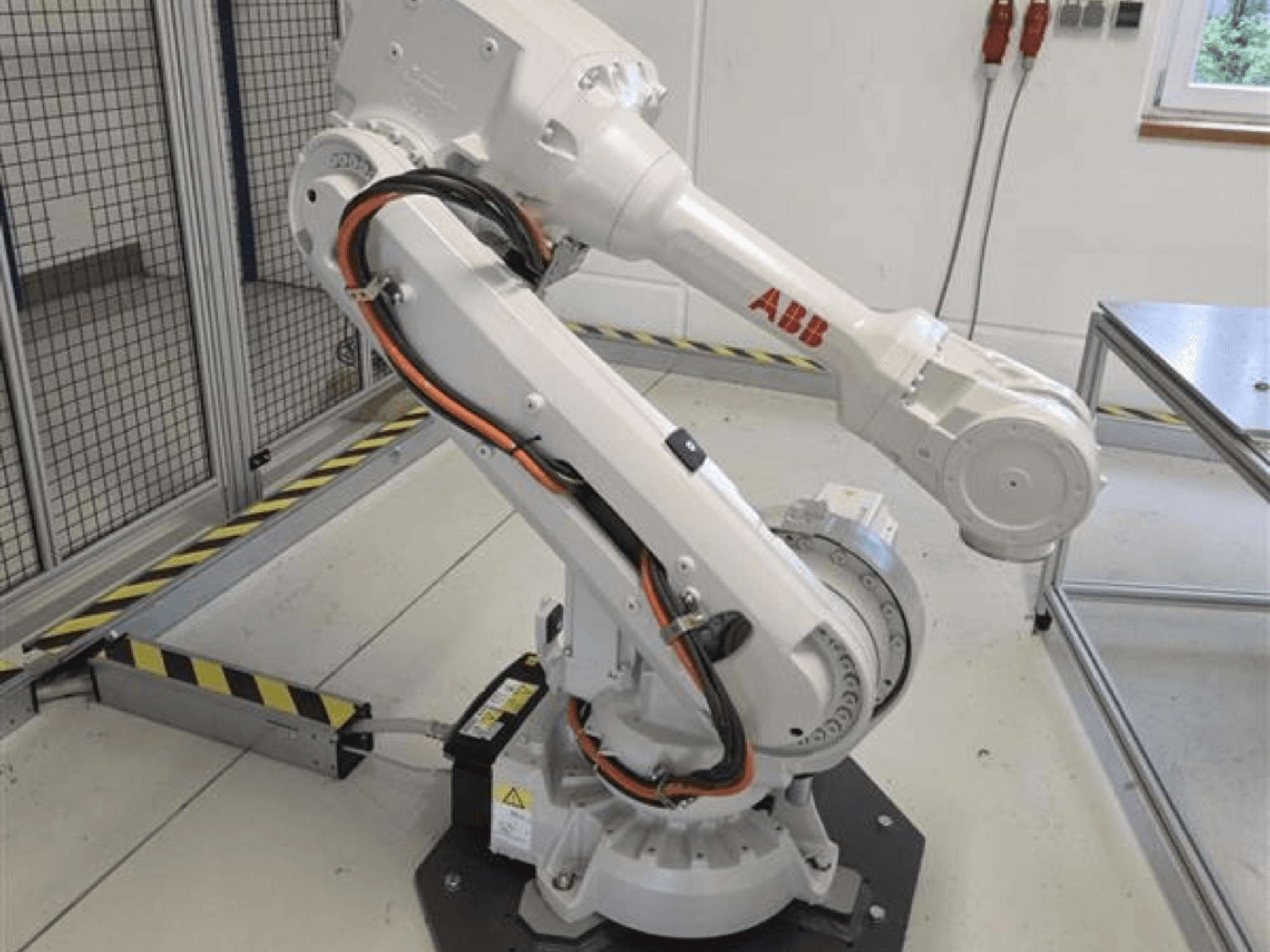 Ramię robota ABB IRB 4600-45/2.05 widziane z profilu, ukazujące jego przegubową konstrukcję oraz kable podłączone do podstawy.