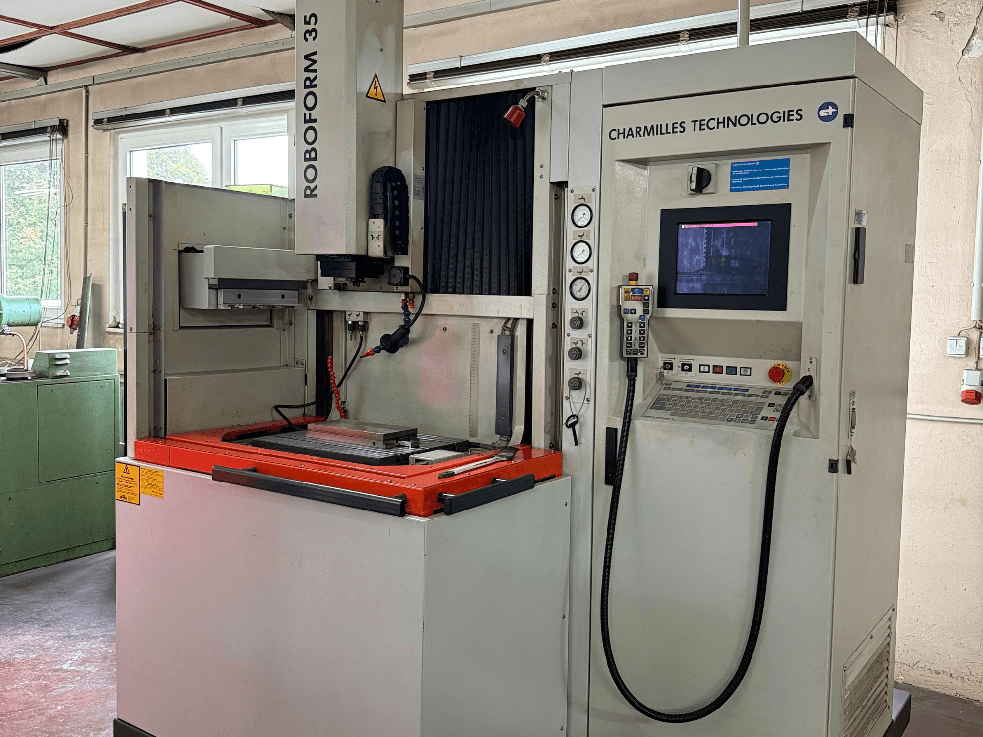 Maszyna Charmilles Technologies Roboforn 35, widok z przodu, pokazujący panel sterowania, zamontowane narzędzia i etykiety bezpieczeństwa.