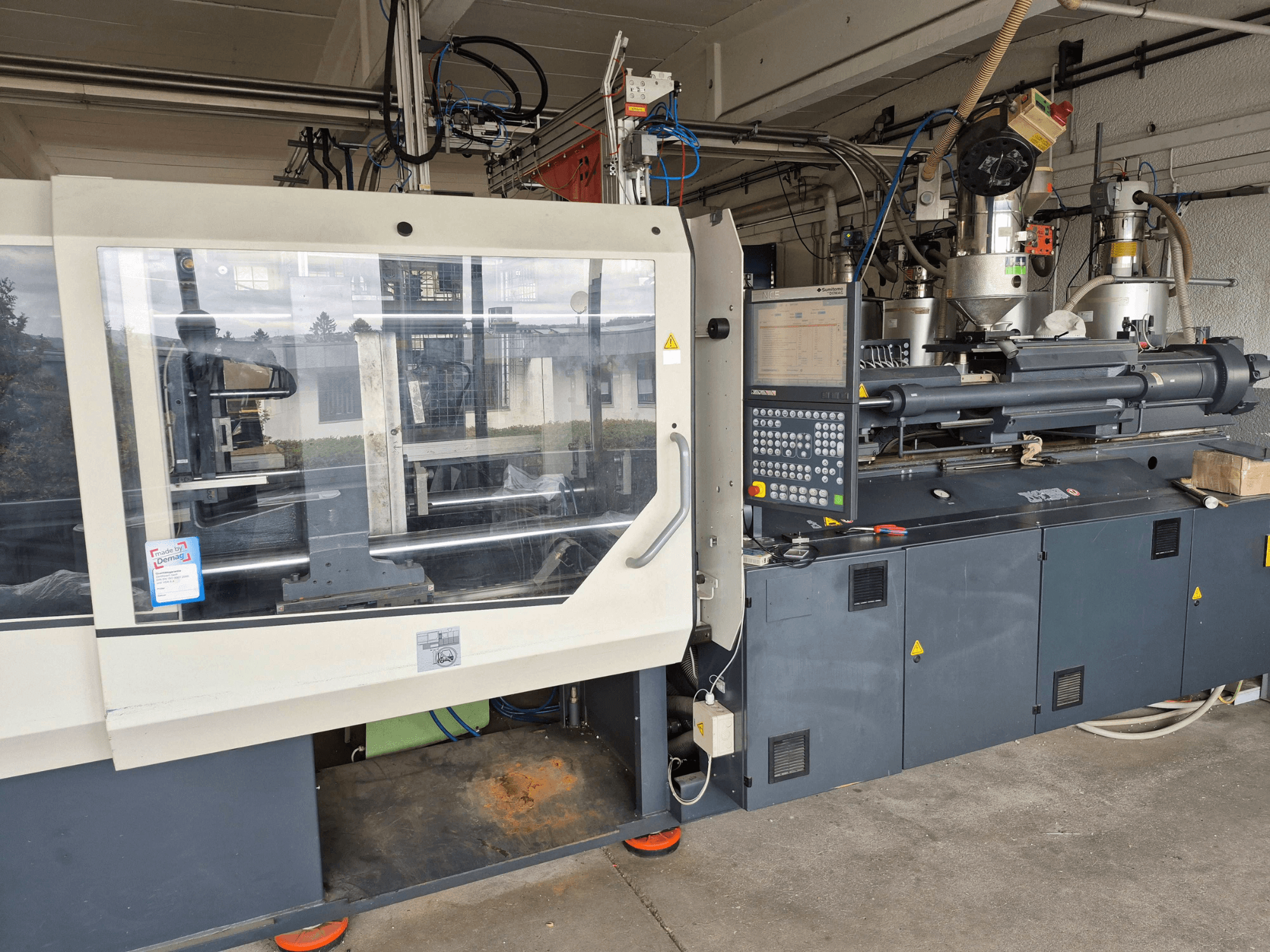 Hydrauliczna wtryskarka, SUMITOMO SHI DEMAG Systec 210/580-1450, widok z przodu z panelem sterowania i widocznymi elementami.