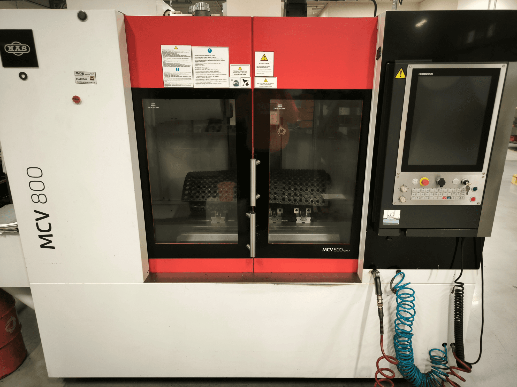 Pionowe centrum obróbcze KOVOSVIT MAS MCV 800 QUICK, widok z przodu z panelem sterowania i podwójnymi szklanymi drzwiami ukazującymi przestrzeń roboczą.