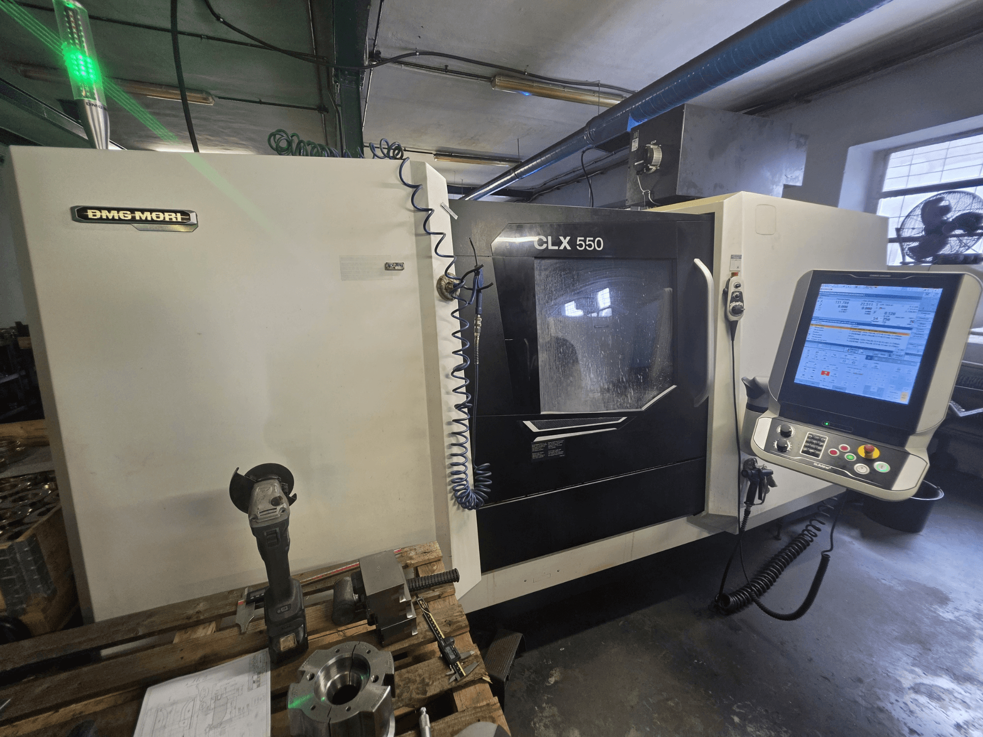 Pozioma tokarka DMG MORI CLX 550 V3 – widok z przodu przedstawiający panel sterowania, narzędzia skrawające oraz obudowę maszyny.