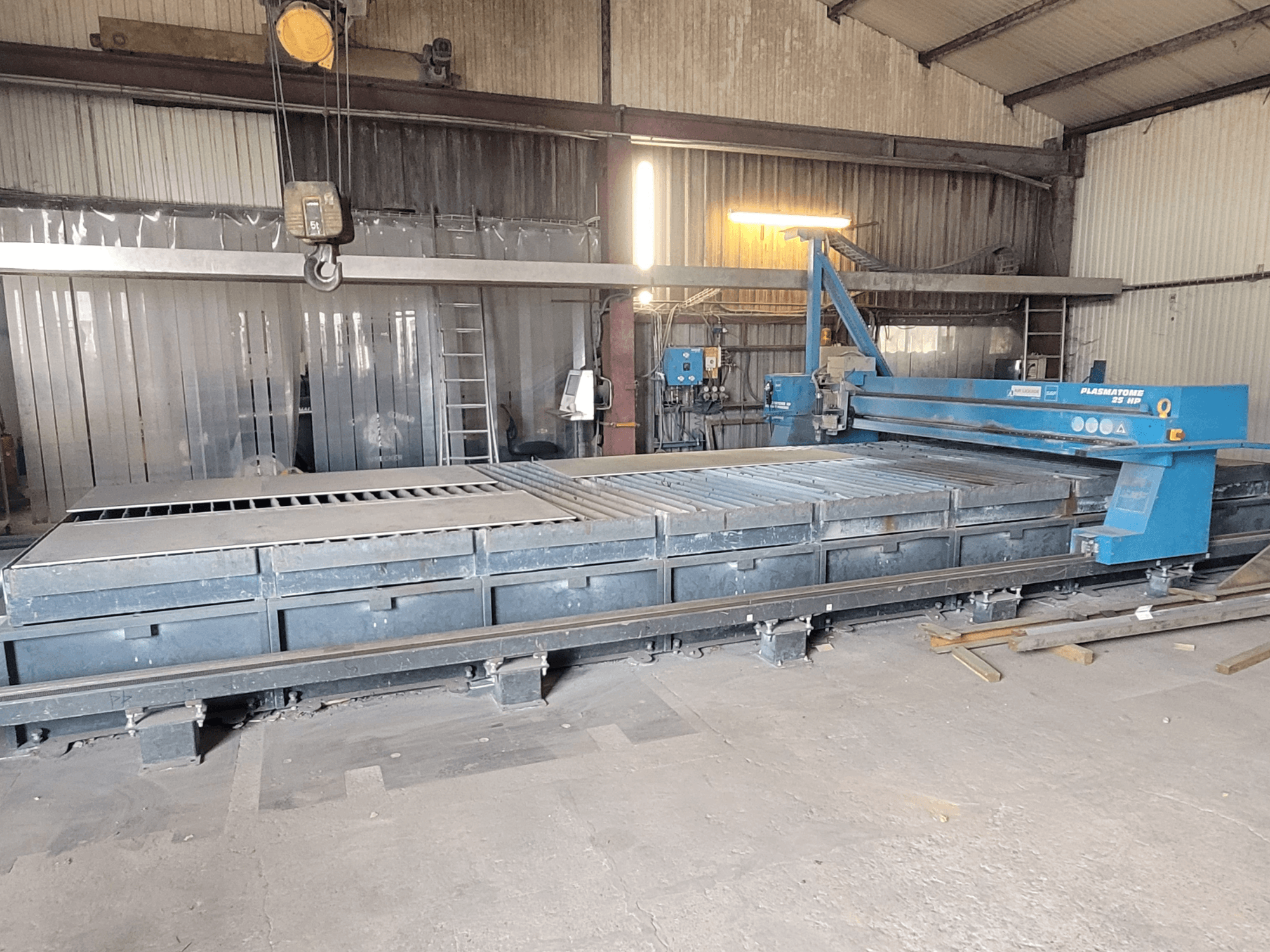 Maszyna do cięcia plazmowego SAF Plasmatone 25Hp, widok z boku, prezentująca stół do cięcia i komponenty operacyjne w warunkach przemysłowych.
