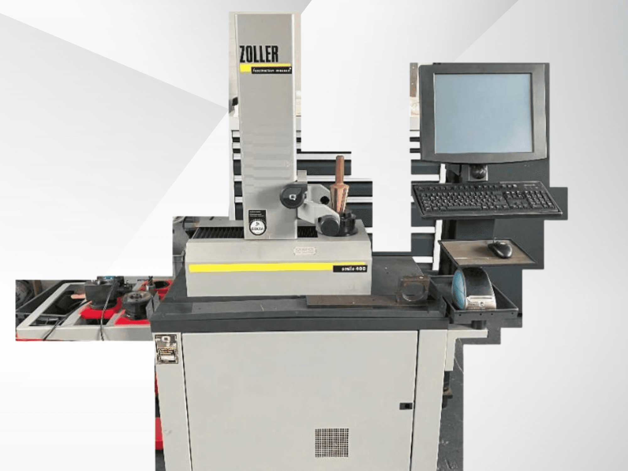 Maszyna pomiarowa ZOLLER z monitorem komputera, klawiaturą i narzędziami; widok z przodu pokazujący szary kolor i nowoczesny design.
