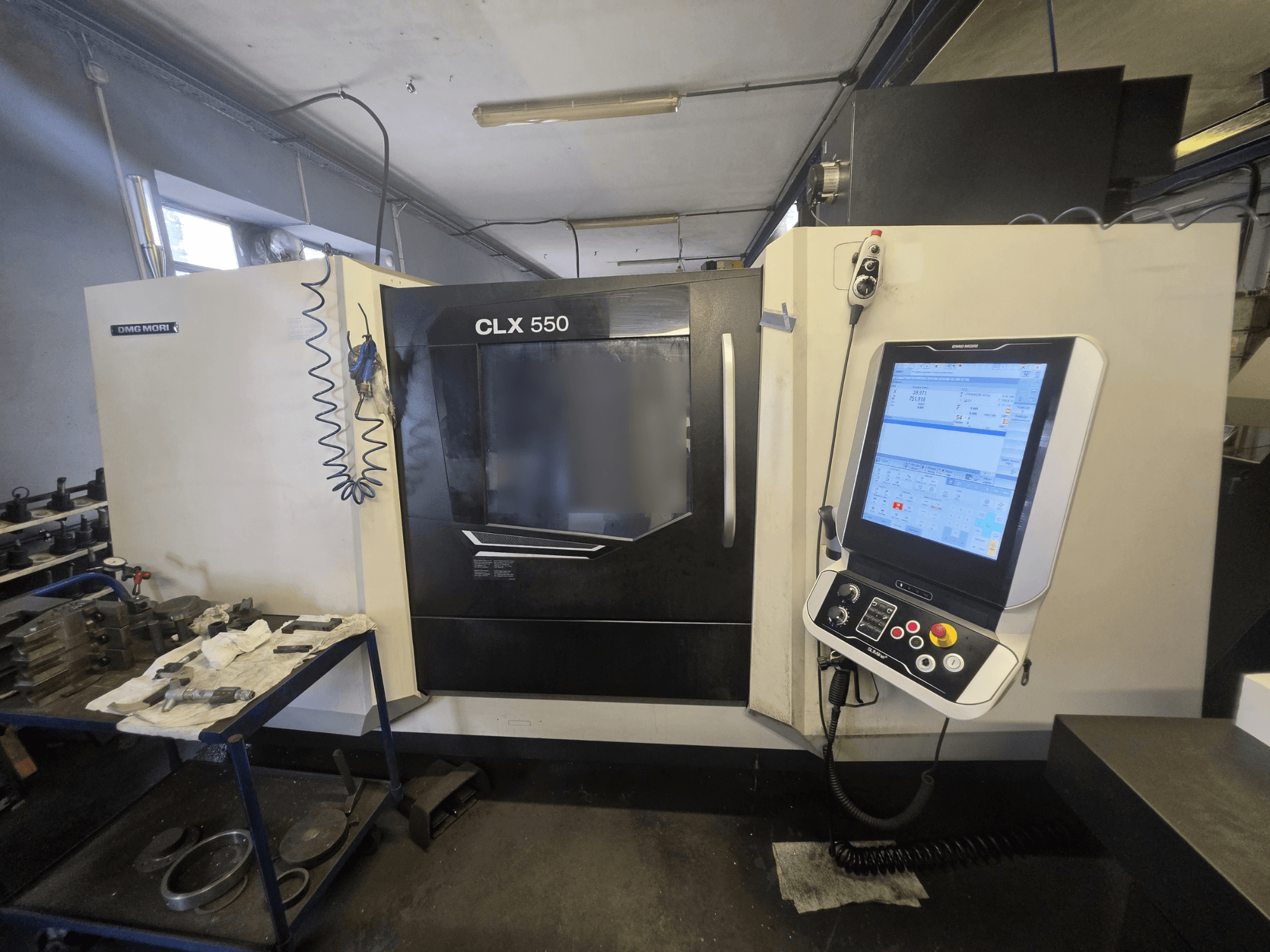 Pozioma tokarka DMG MORI CLX 550 V3, widok z przodu, przedstawiająca panel sterowania oraz obszar roboczy z narzędziami.