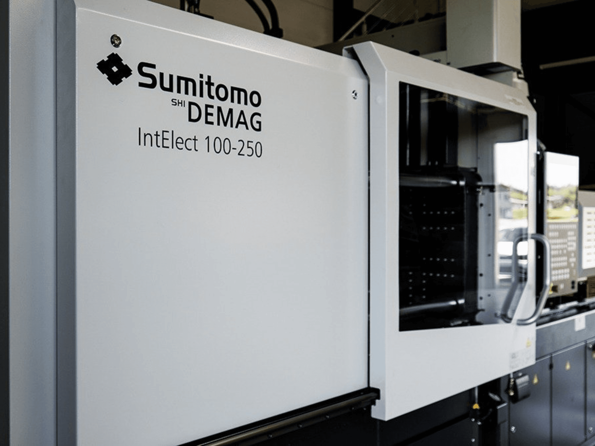Widok z przodu elektrycznej wtryskarki SUMITOMO SHI DEMAG IntElect 100/250 wraz z panelem sterowania i elementami zabezpieczającymi.