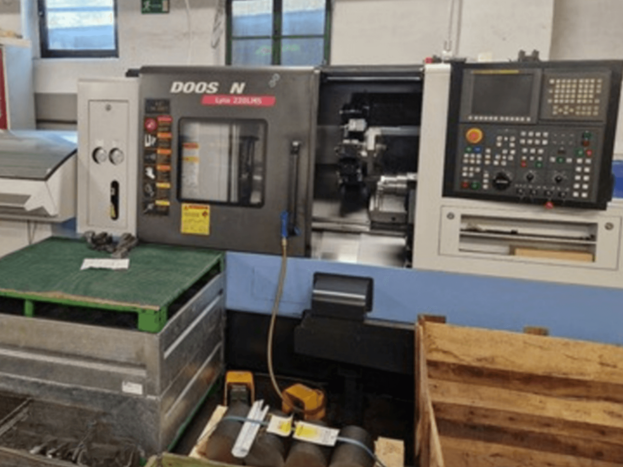 Tokarka pozioma DOOSAN Lyax 220 LMS w widoku z przodu, z panelem sterowania, narzędziami i przestrzenią roboczą.