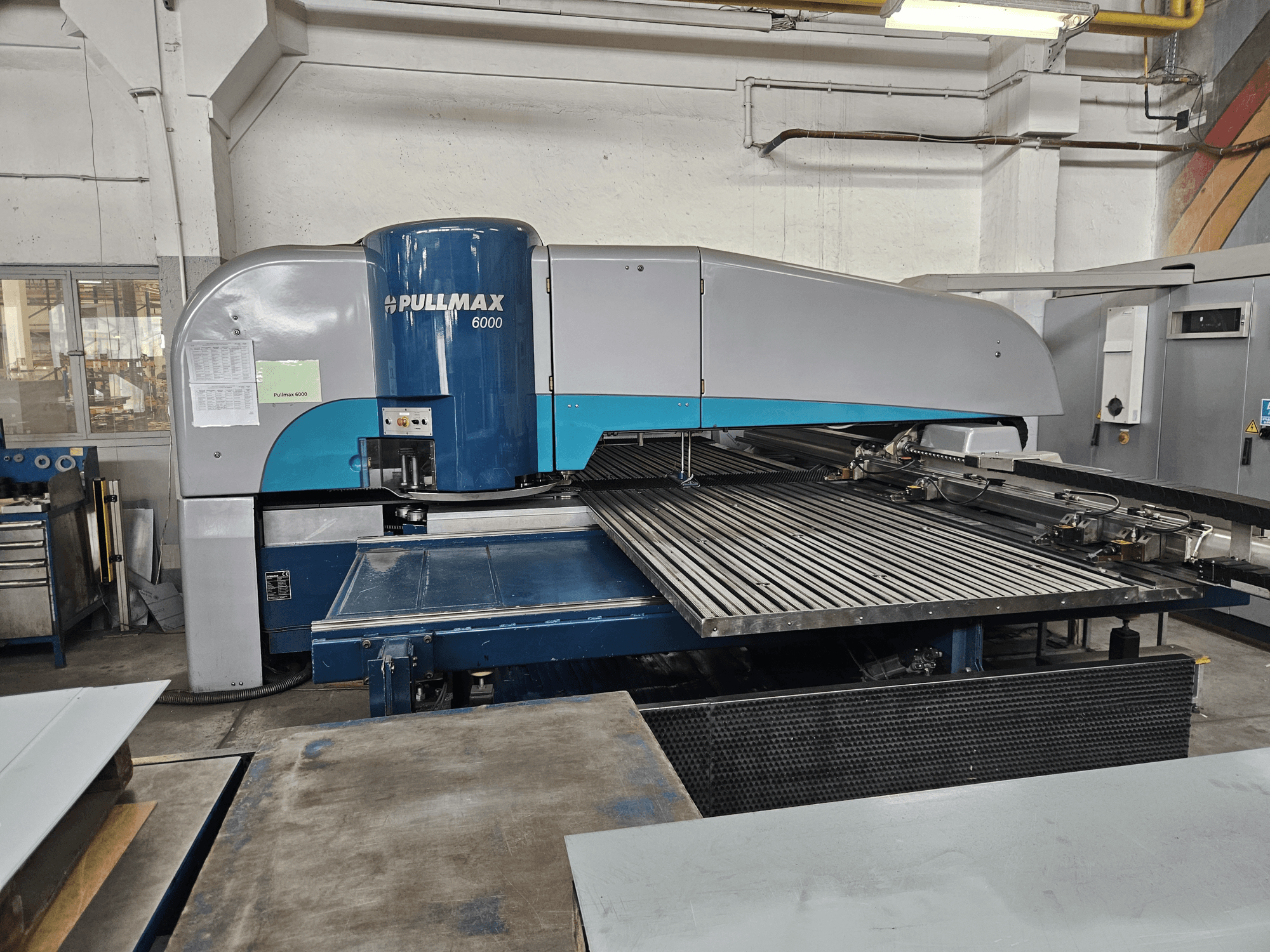 Widok z przodu wykrawarki CNC Pullmax 6000, prezentujący jej duże płaskie łoże i metalową ramę w warunkach warsztatowych.