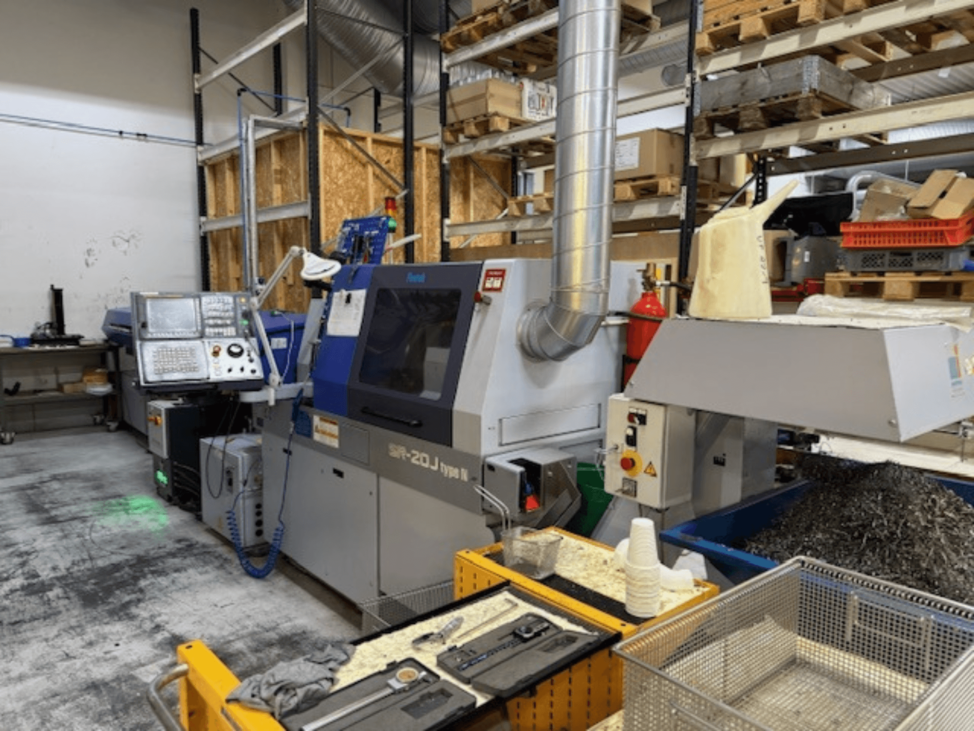 Widok z przodu centrum obróbczego Faroh SPR-20J typu N z panelem sterowania, wiórami metalowymi i sprzętem zabezpieczającym w warsztacie.