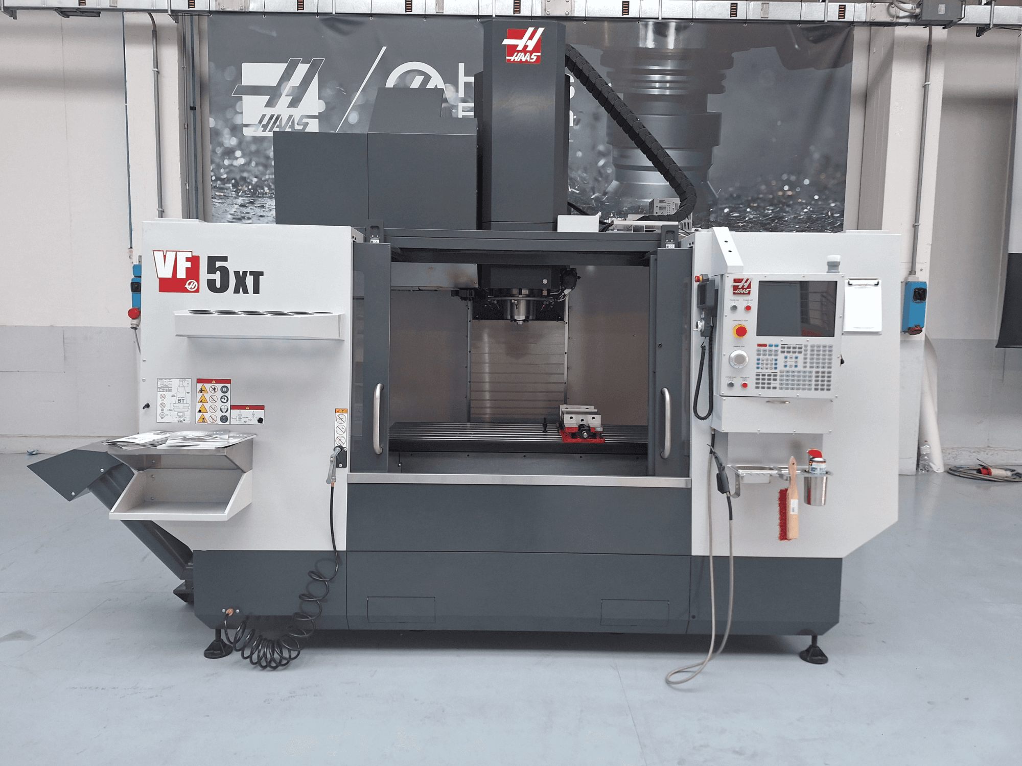 Pionowe centrum obróbcze HAAS VF-5/50XT, widok z przodu, przedstawiający panel sterowania, obszar wrzeciona oraz magazyn narzędzi.