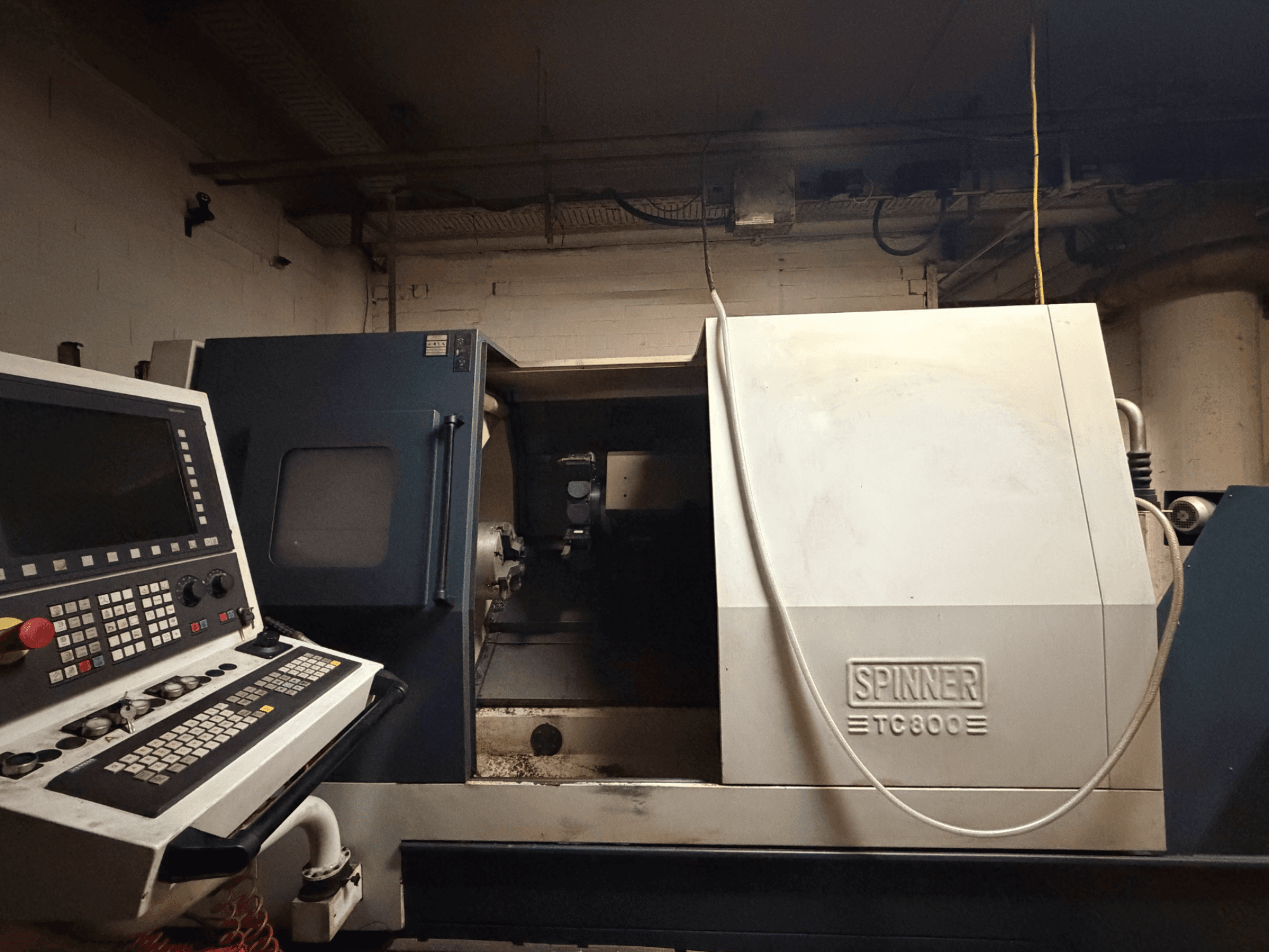 Tokarka pozioma SPINNER TC800, widok z przodu z widocznym panelem sterowania i lekko odsłoniętym wnętrzem maszyny.