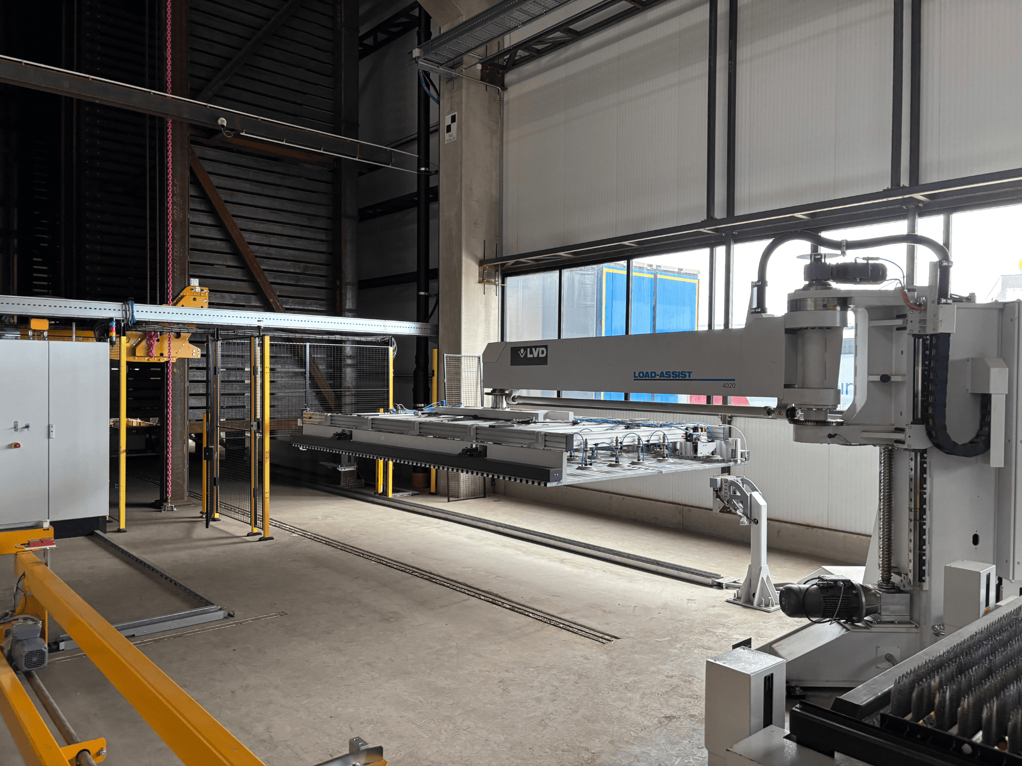 Sprzęt do automatyzacji LVD Load-Assist 4020 w widoku z przodu z ramieniem robotycznym i systemem załadunku widocznym w dużej przestrzeni roboczej.