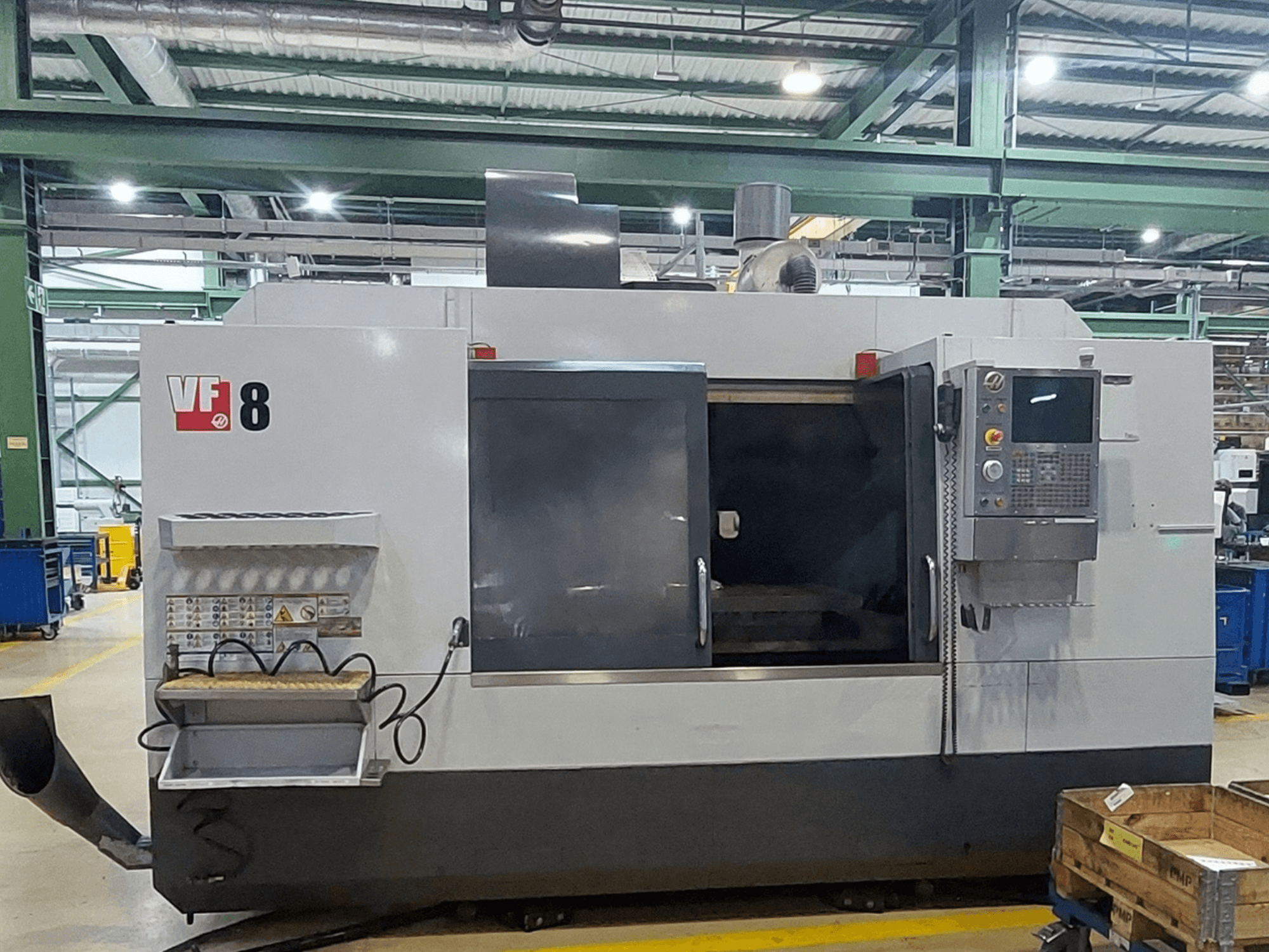 Pionowe centrum obróbcze HAAS VF-8, widok z przodu; wyposażone w panel sterowania i strefę załadunku, przeznaczone do precyzyjnych zadań obróbczych.