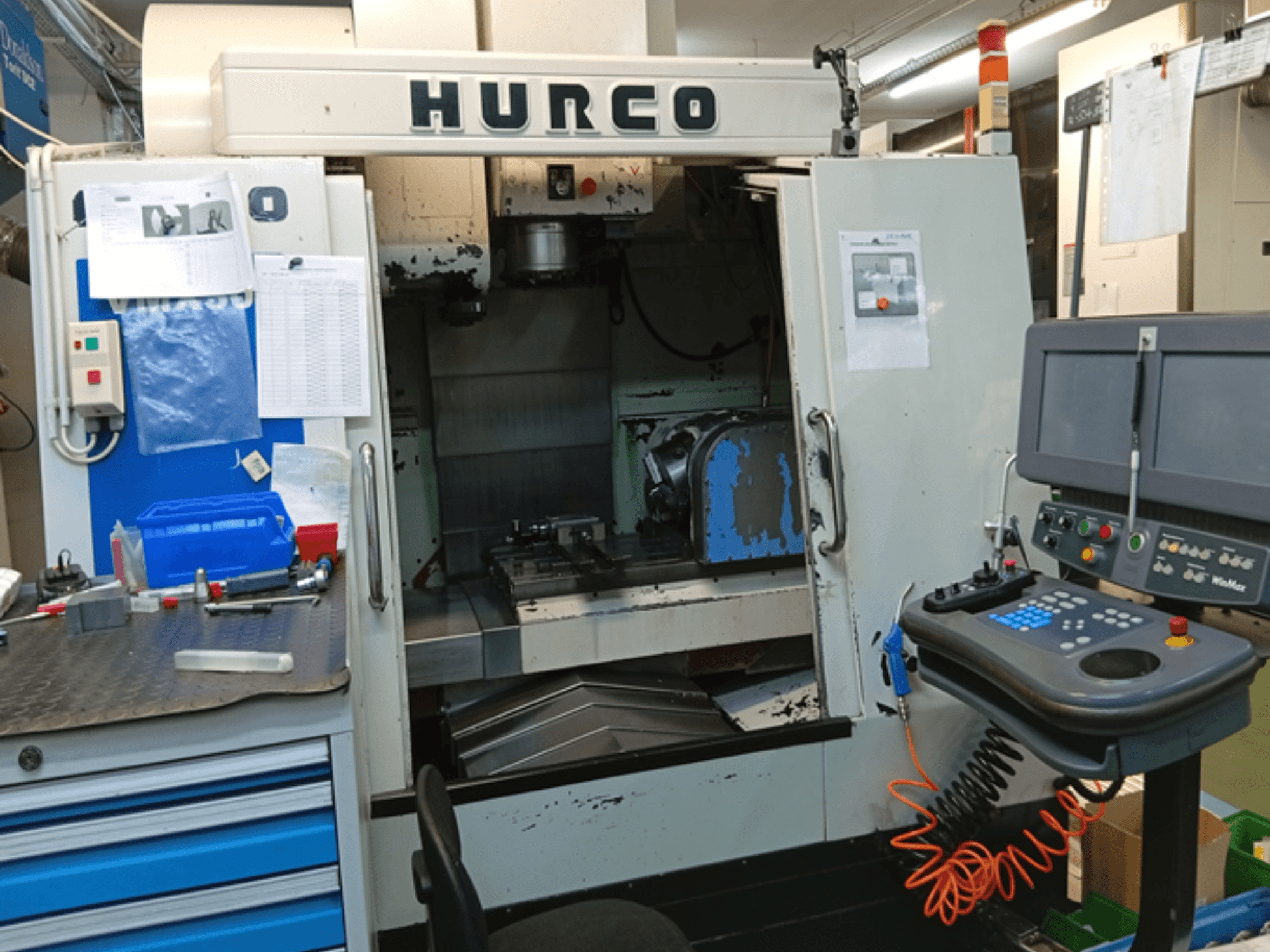 Pionowe centrum obróbcze Hurco VMX 30T, widok z przodu, pokazujący panel sterowania, obszar roboczy i częściowo otwarte drzwi.