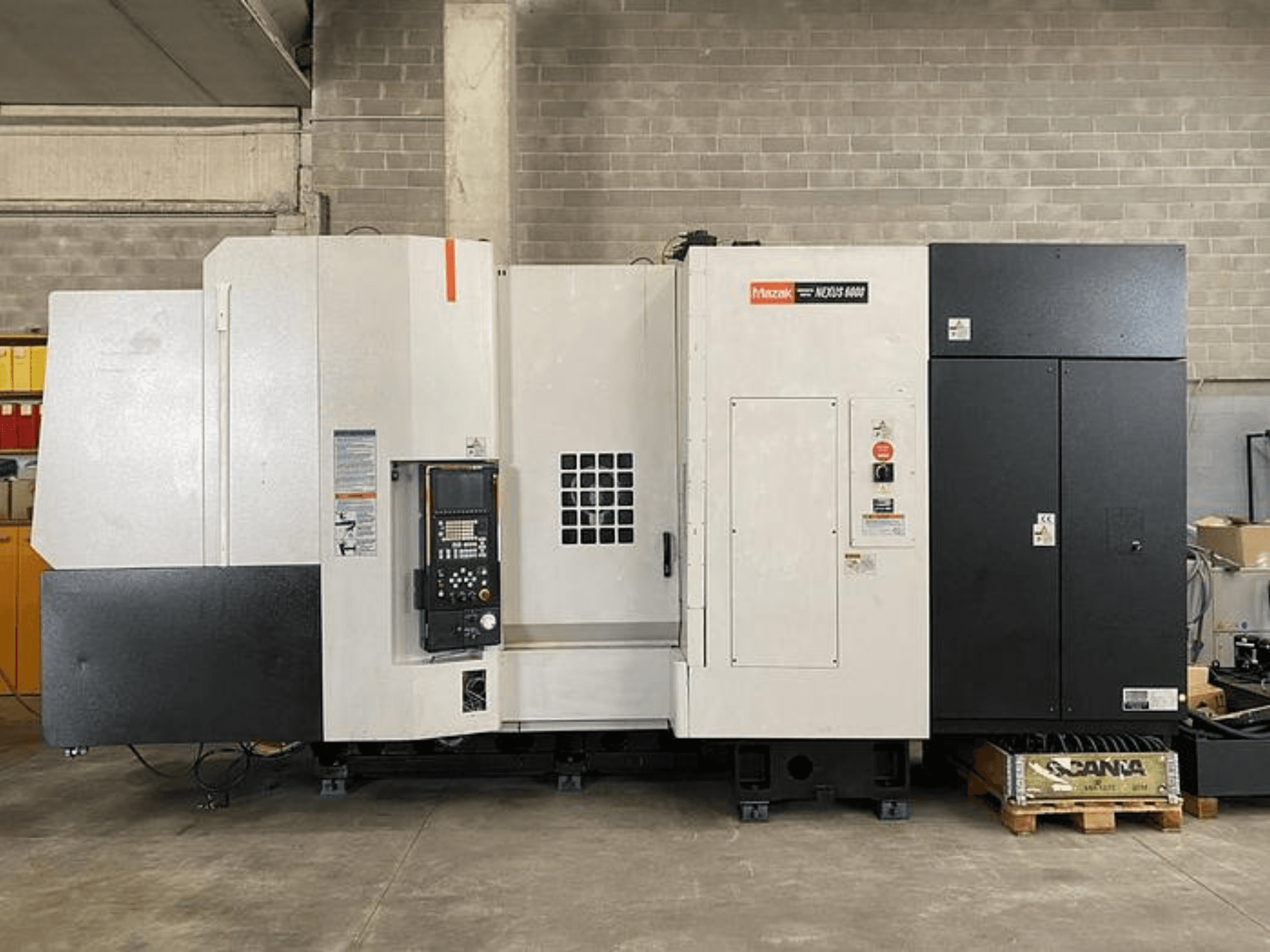 Tokarka CNC Mazak NEXUS 6400, widok z przodu, z panelem sterowania, wyłącznikiem zasilania i dwukolorową biało-czarną obudową.