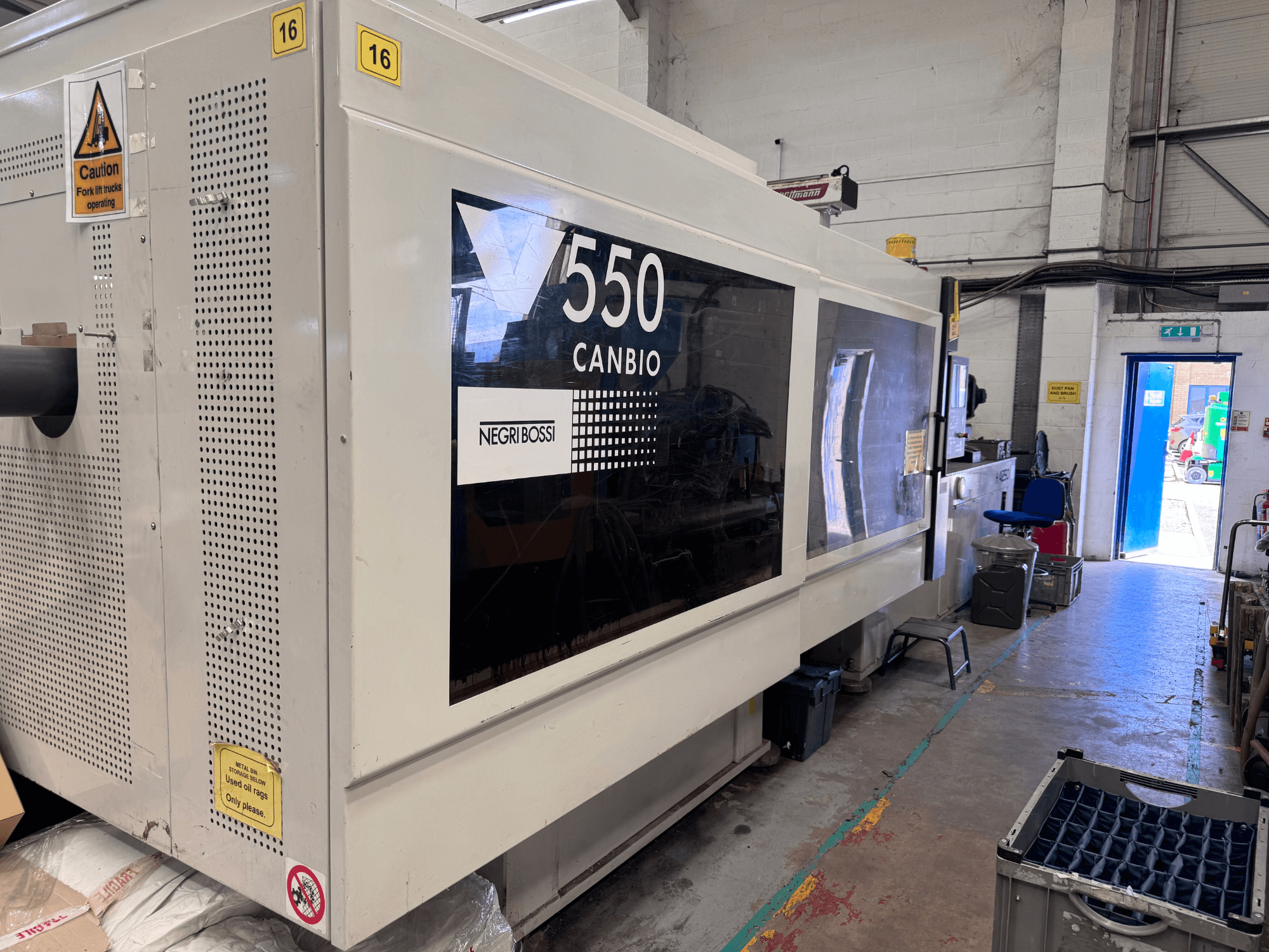 Hydrauliczna wtryskarka Negri Bossi 5500H-4250 – widok z przodu przedstawiający panel sterowania i znaki ostrzegawcze.