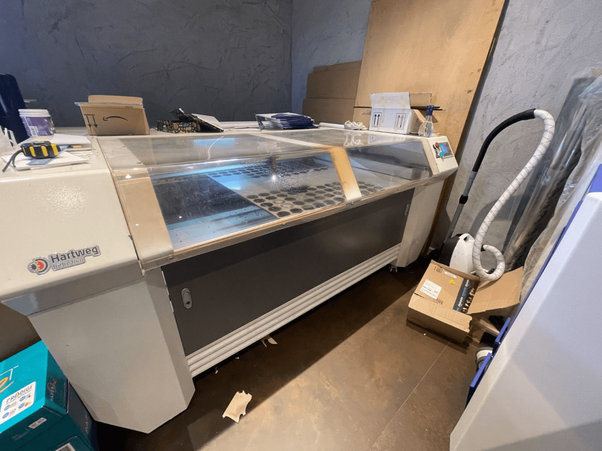 Wycinarka laserowa CO2 Bodor CL-1610XUF w widoku z boku, pokazująca obszar roboczy ze szczelinami materiałowymi i panelem sterowania.