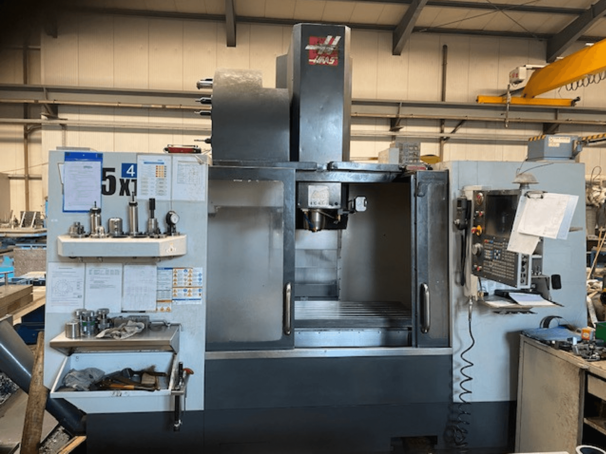 Pionowe centrum obróbcze Haas VF-5, widok z przodu, panel sterowania, magazyn narzędzi i obszar wrzeciona.