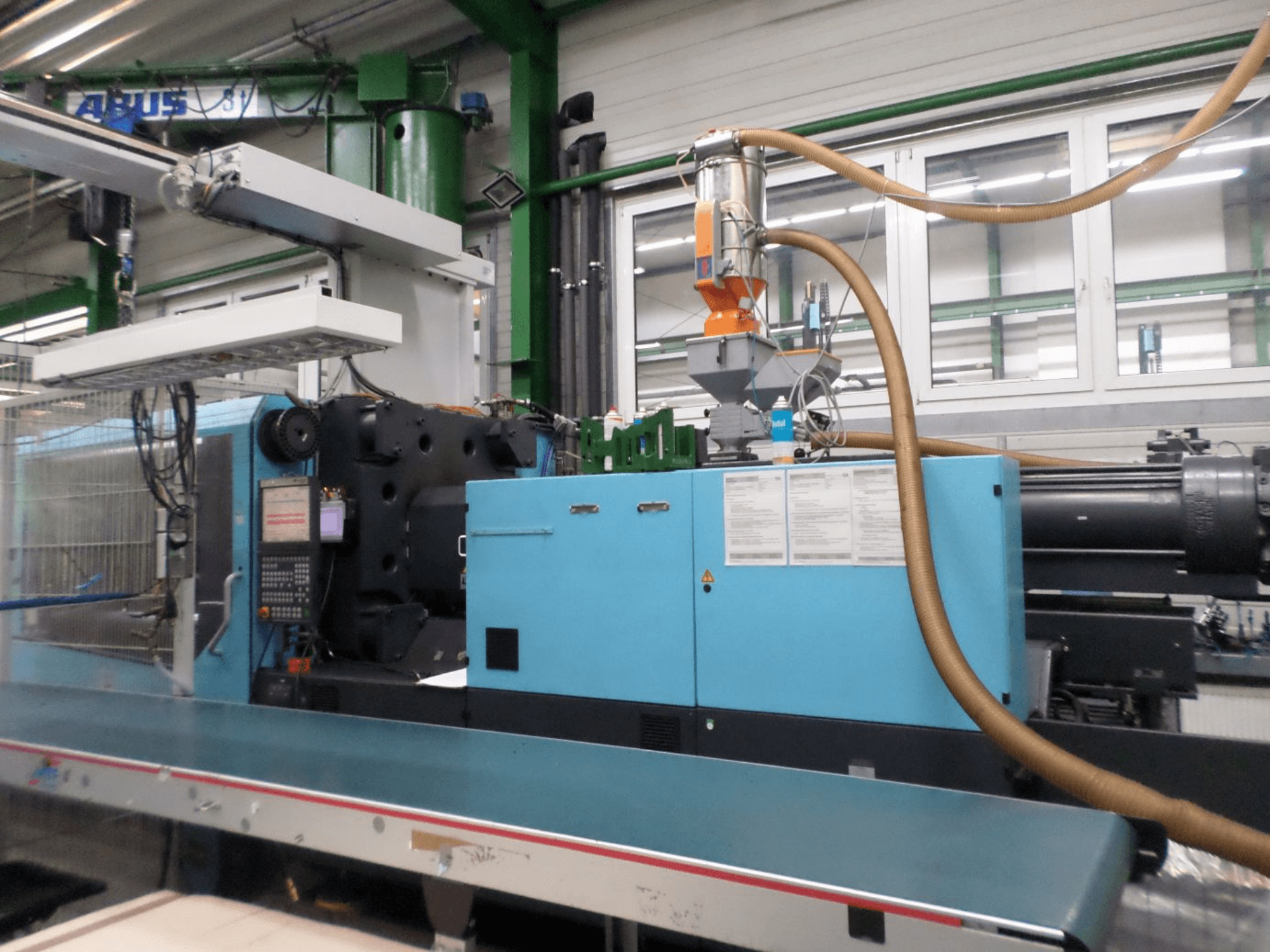 Widok z przodu hydraulicznej wtryskarki DEMAG D 420, przedstawiający panel sterowania, zasobnik oraz elementy hydrauliczne.