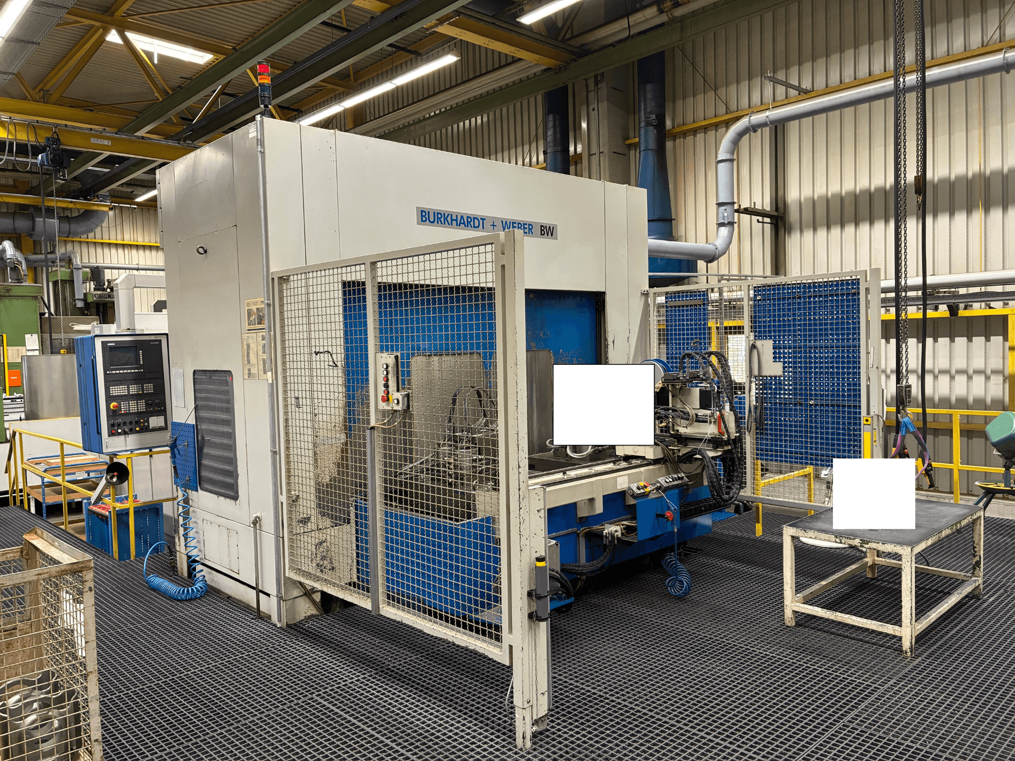 Centrum obróbcze Burkhardt + Weber BW, widok z przodu, z panelem sterowania i obudową bezpieczeństwa, umieszczone w otoczeniu przemysłowym.