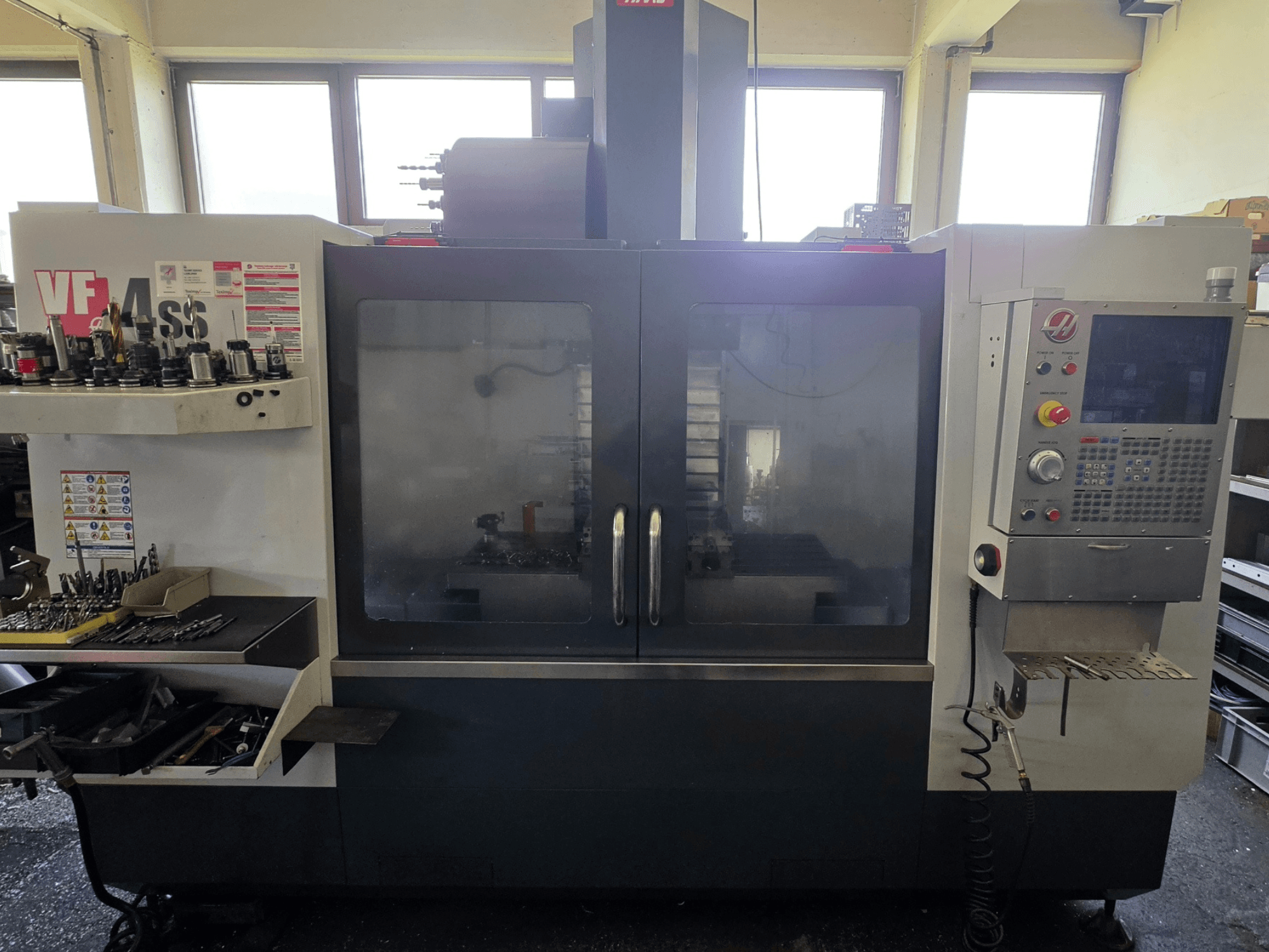 Pionowe centrum obróbcze HAAS VF 34SS - widok z przodu, panel sterowania i obszar przechowywania narzędzi.
