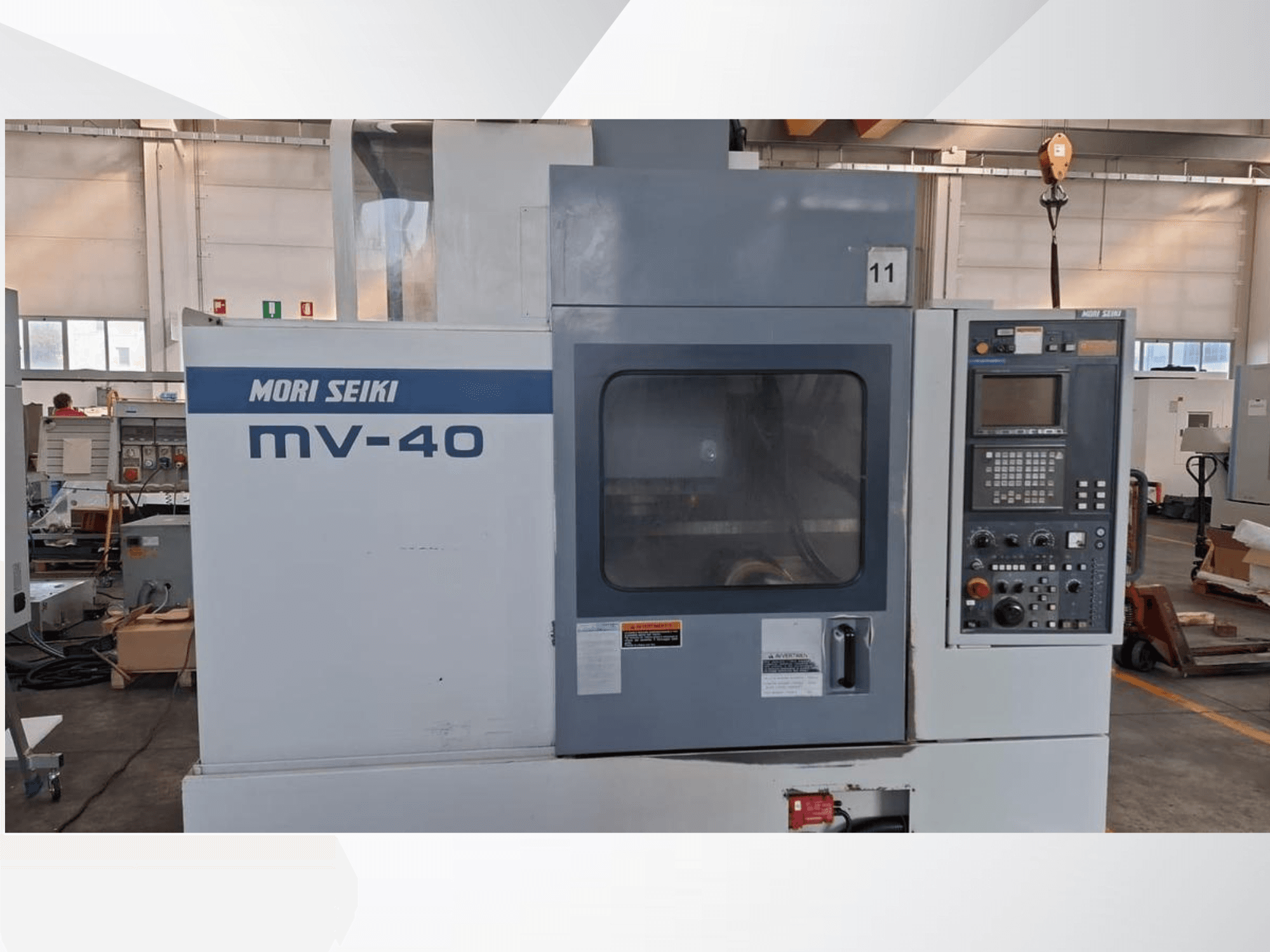 Pionowe centrum obróbcze MORI SEIKI MV-40, widok z przodu przedstawiający panel sterowania i okno, w warunkach warsztatowych.