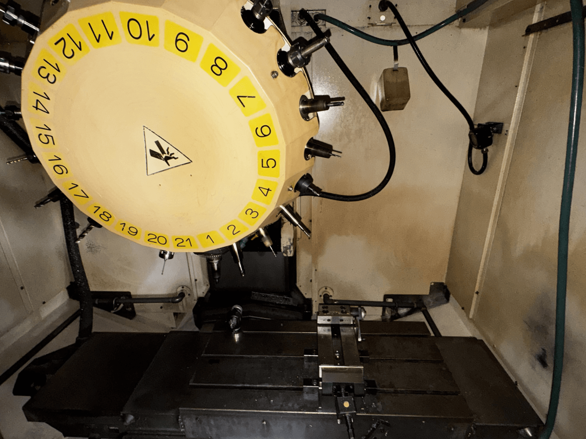 Widok wnętrza pionowego centrum obróbczego FANUC Robodrill alpha-T21iFL z widoczną karuzelą narzędziową i stołem obróbczym.