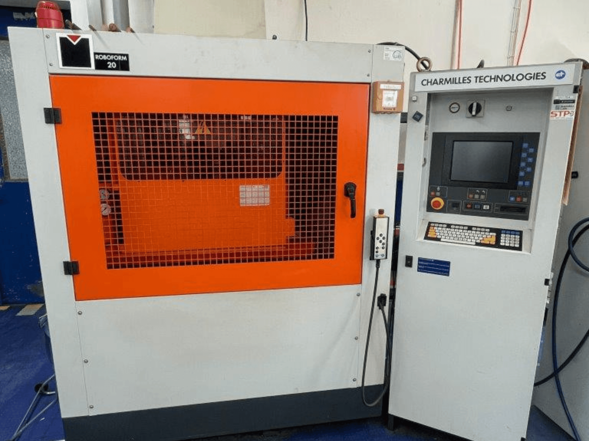 Elektrodrążarka wgłębna AgieCharmilles Robofrom 20, widok z przodu z panelem sterowania i pomarańczową kratką ochronną.