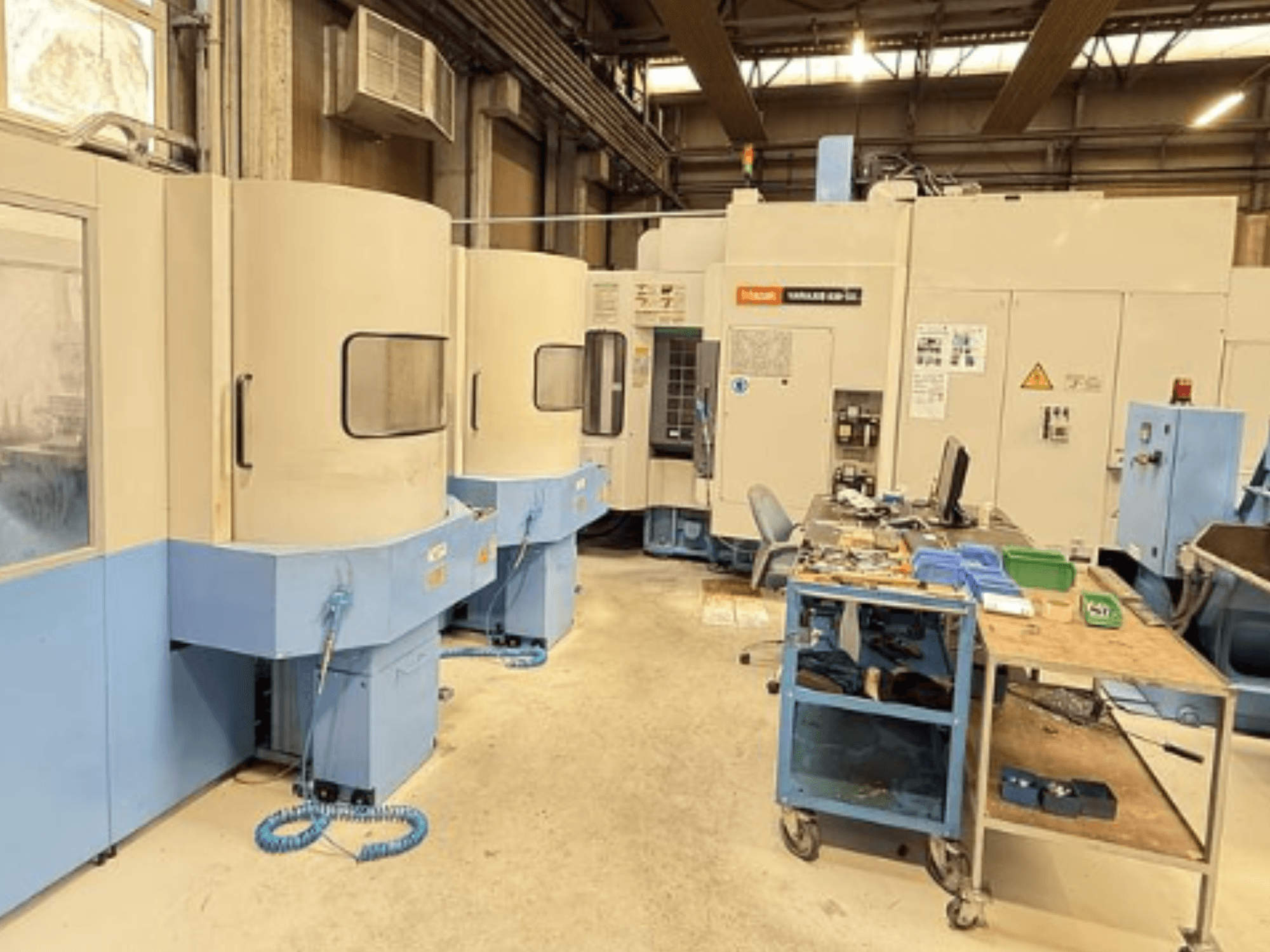 Pionowe centrum obróbcze Mazak Variaxis 630-5X w warsztacie, widok z przodu przedstawiający panel sterowania i obszar przechowywania narzędzi.