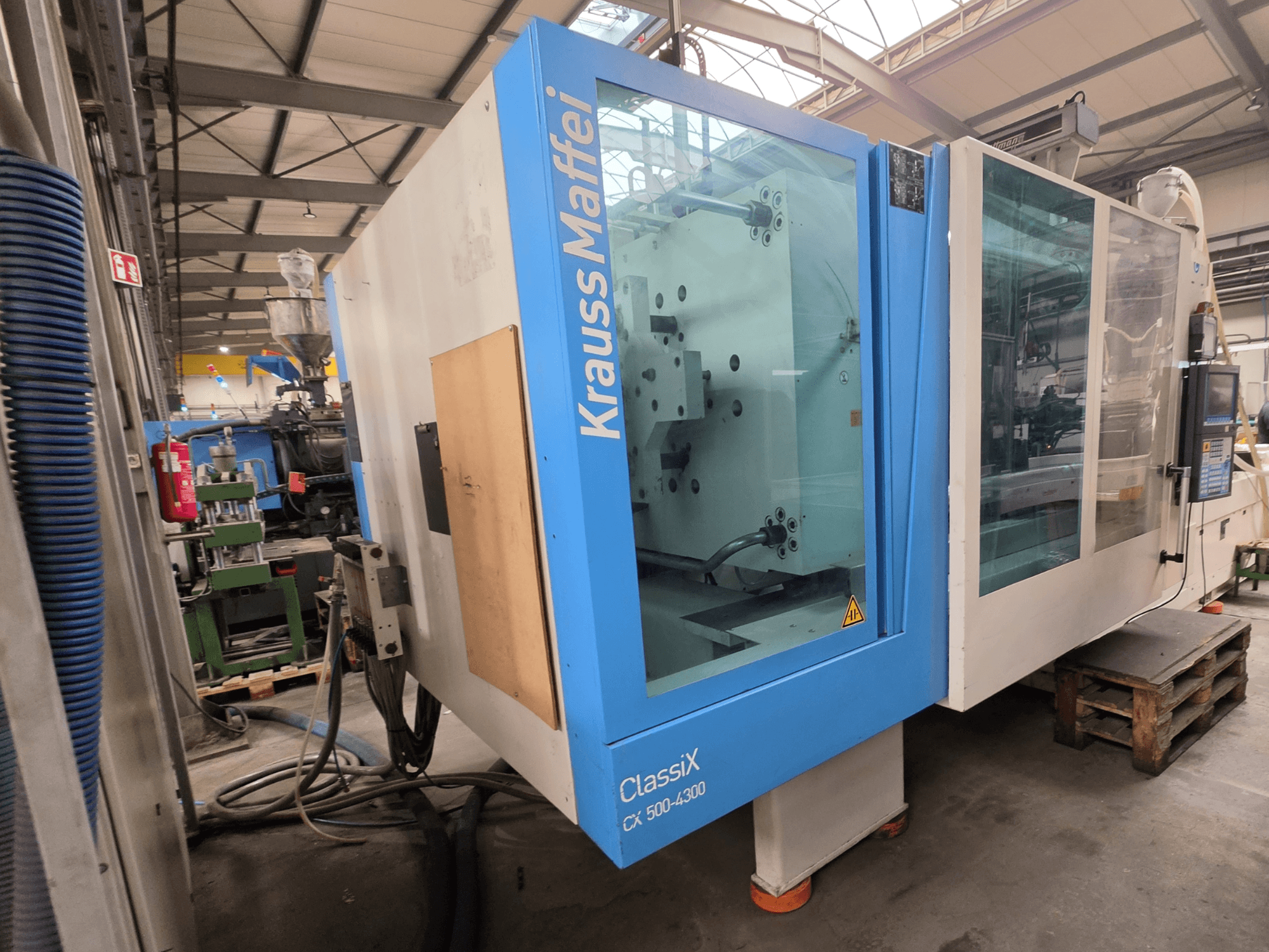 Hydrauliczna wtryskarka Krauss Maffei 500-4300 CX, widok z boku, panel sterowania i komponenty operacyjne.