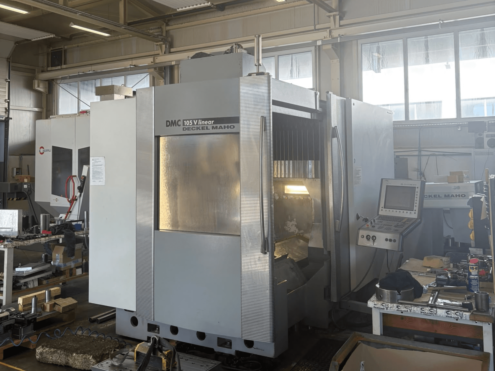 DMG DECKEL MAHO DMU 105 V – liniowe pionowe centrum obróbcze, widok z przodu przedstawiający panel sterowania i obszar roboczy.
