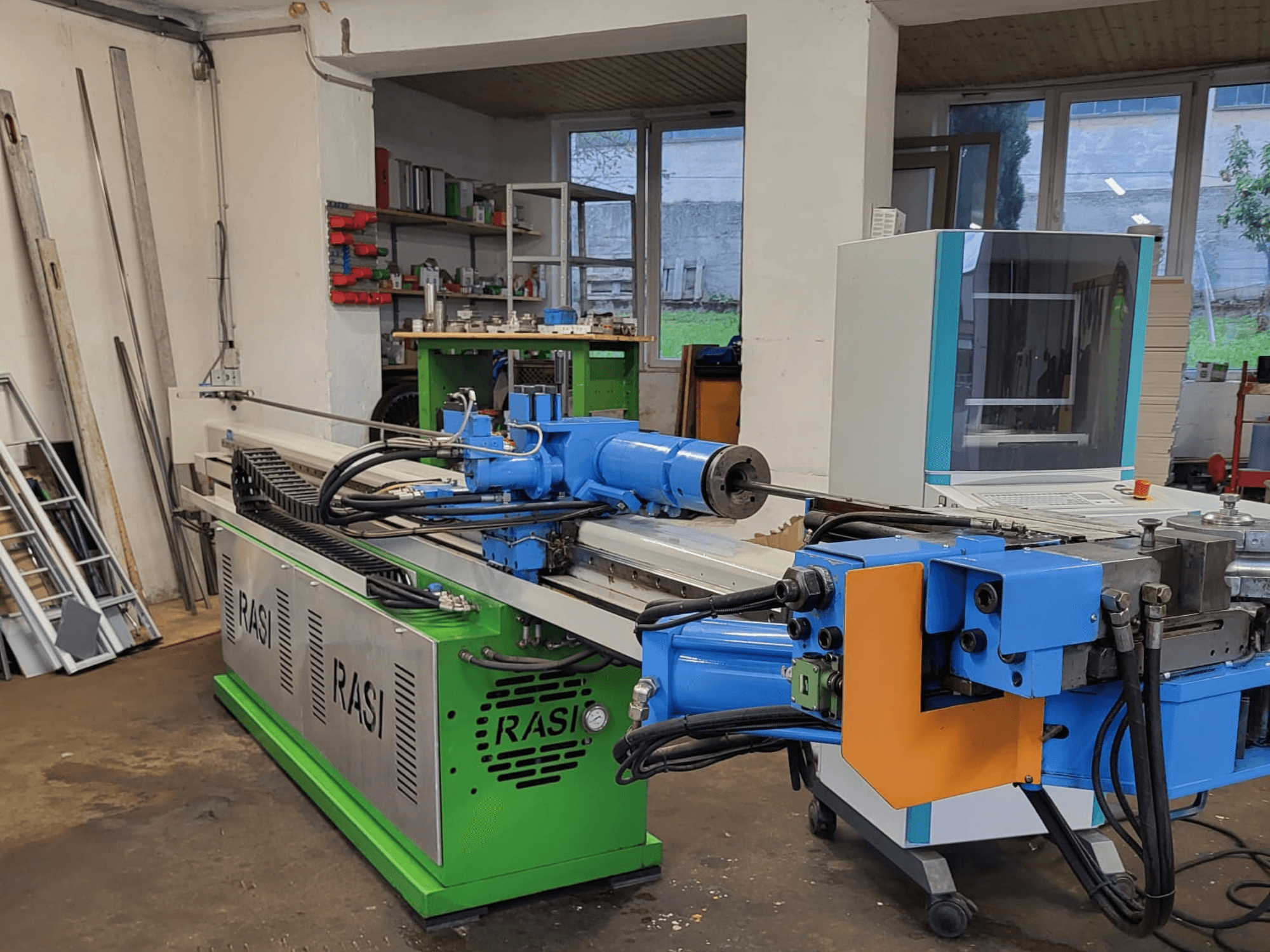 Obrabiarka Rasi S 80.6 L G-V3C50 w warunkach warsztatowych, widok z boku przedstawiający niebieskie i zielone komponenty oraz panel sterowania.