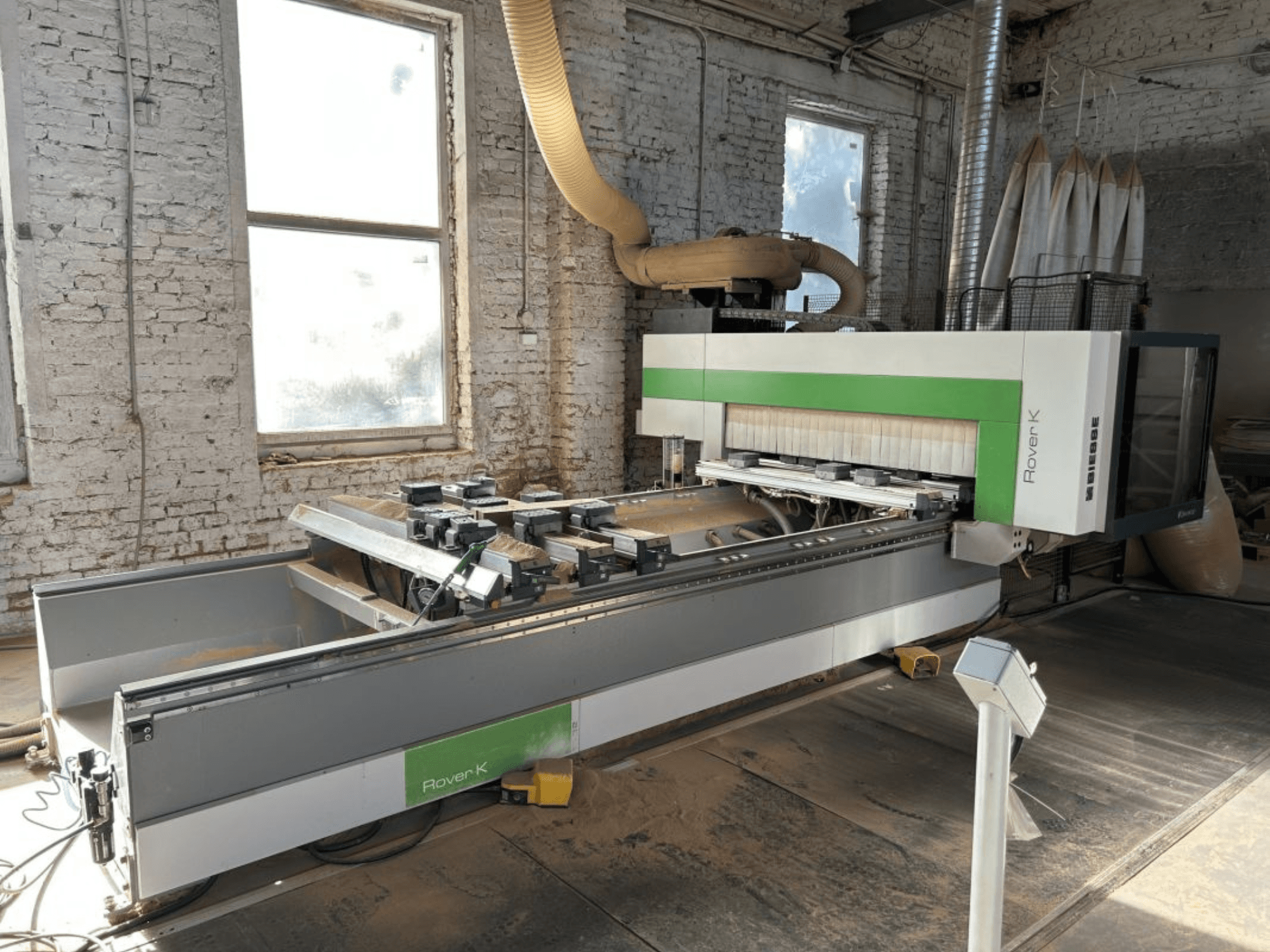 Centrum obróbcze CNC BIESSE Rover K 1532 G w warsztacie, widok od przodu, z widocznymi narzędziami tnącymi i powierzchnią roboczą.