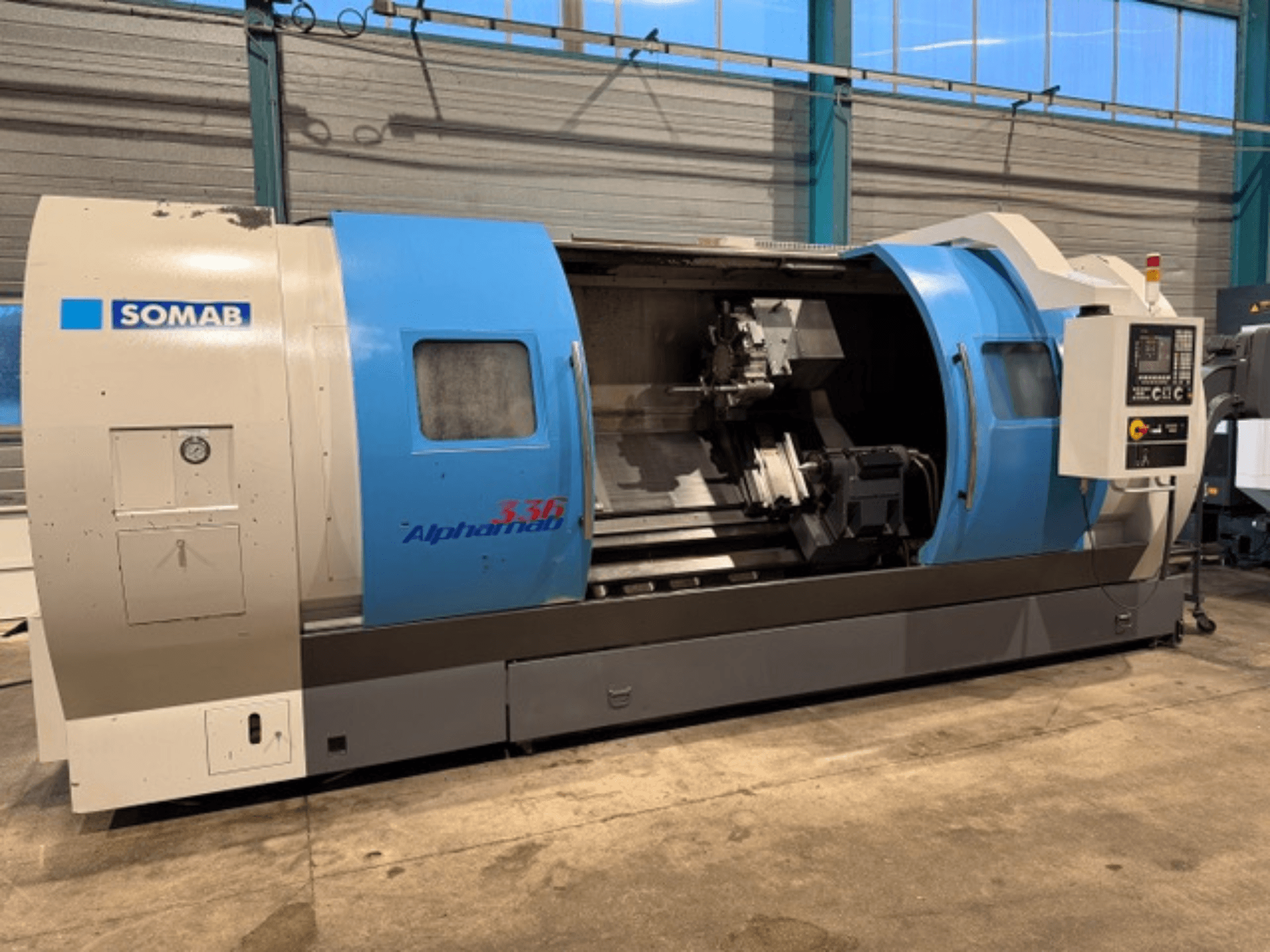 Tokarka CNC SOMAB Alpha 336, widok z przodu, z niebiesko-szarą obudową i panelem sterowania z boku do obsługi.